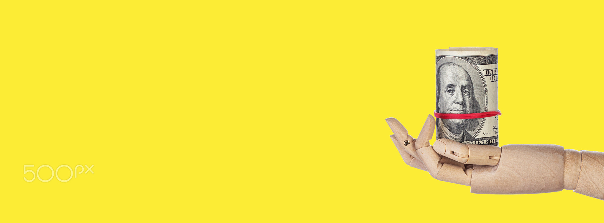 Wooden hand with money isolated on yellow background