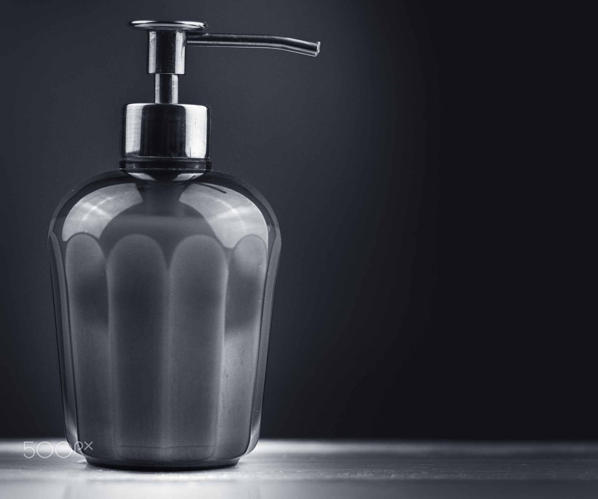 Soap container with a silver manual dispenser