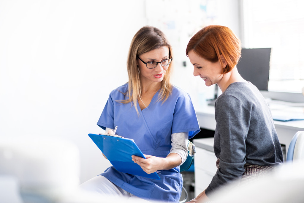 A dentist talking to woman in dentist surgery, a dental check-up. by Jozef Polc on 500px.com