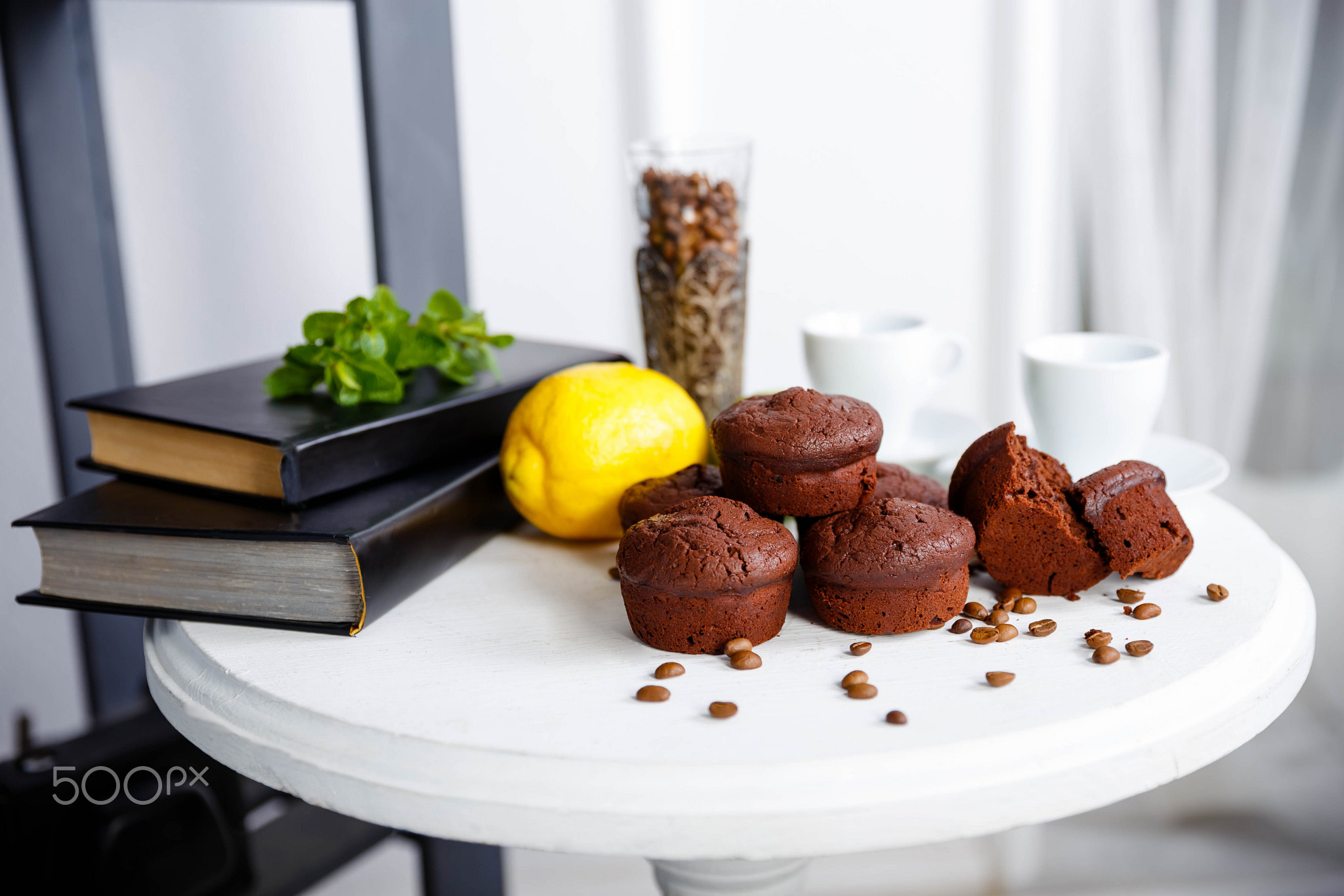 Chocolate cupcakes with coffee beans on a white wooden table