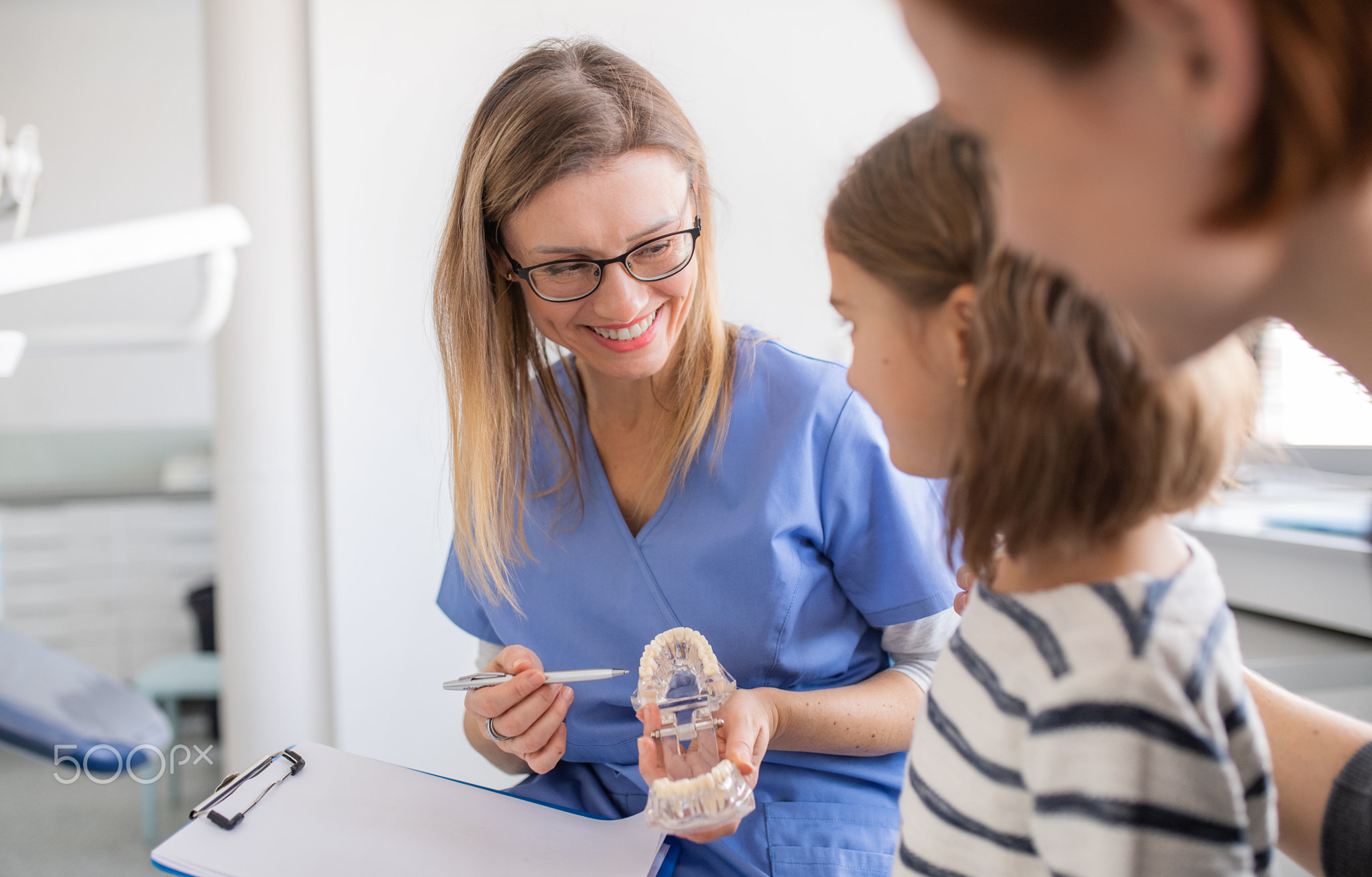 A small girl, mother and dentist in surgery, dental checkup.