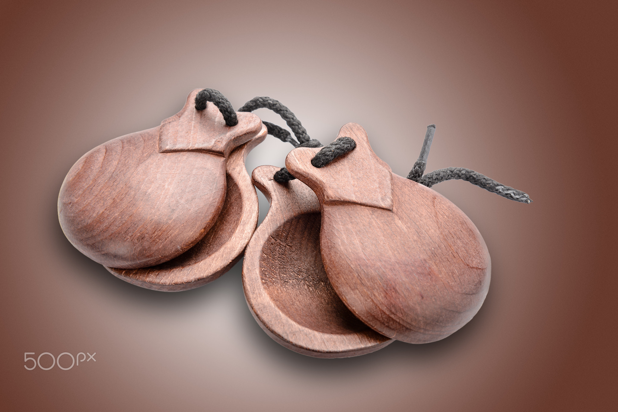 Brown, wooden castanetes on brown background.