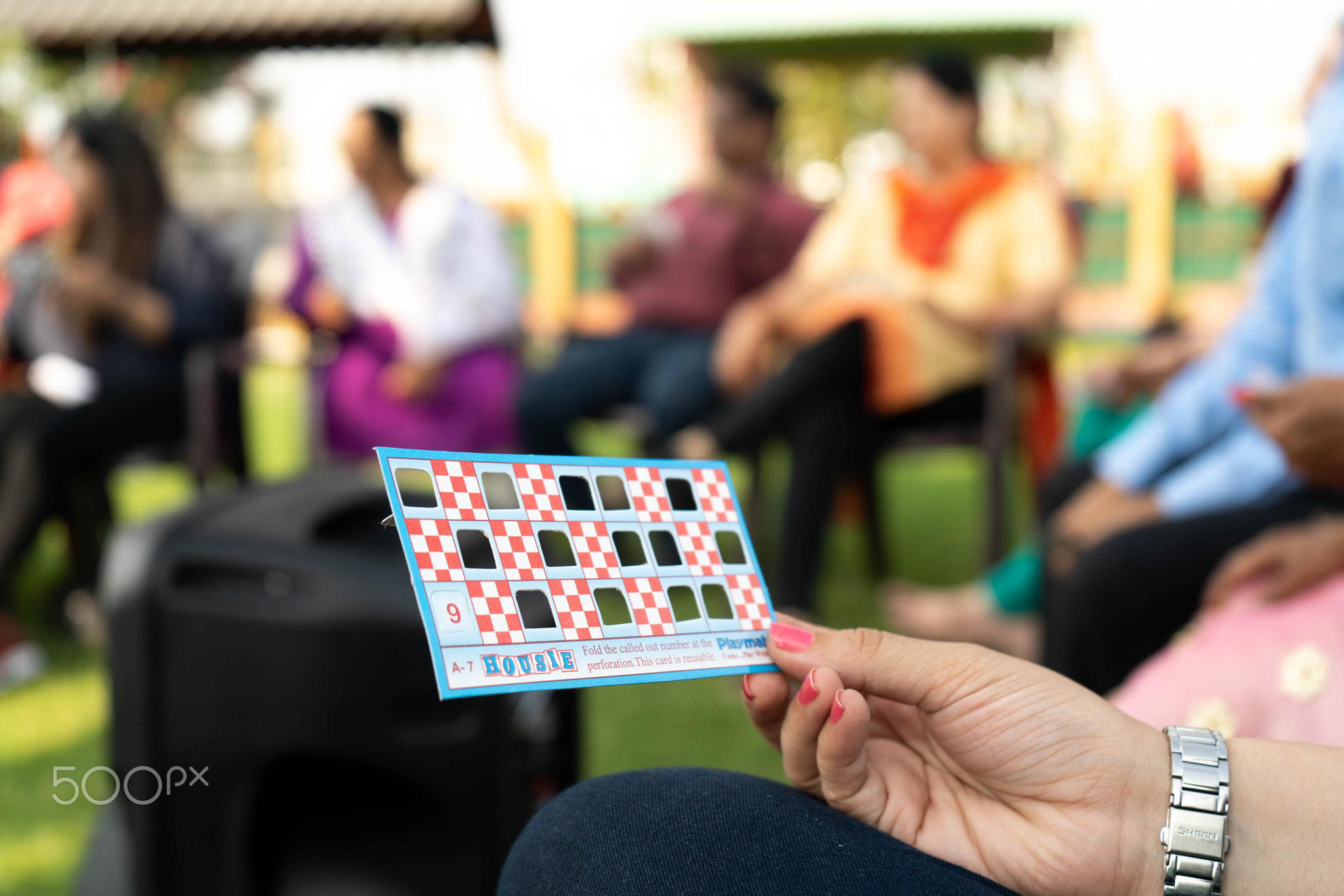 Selective focus shot of hands tolding tambola bingo housie tickets