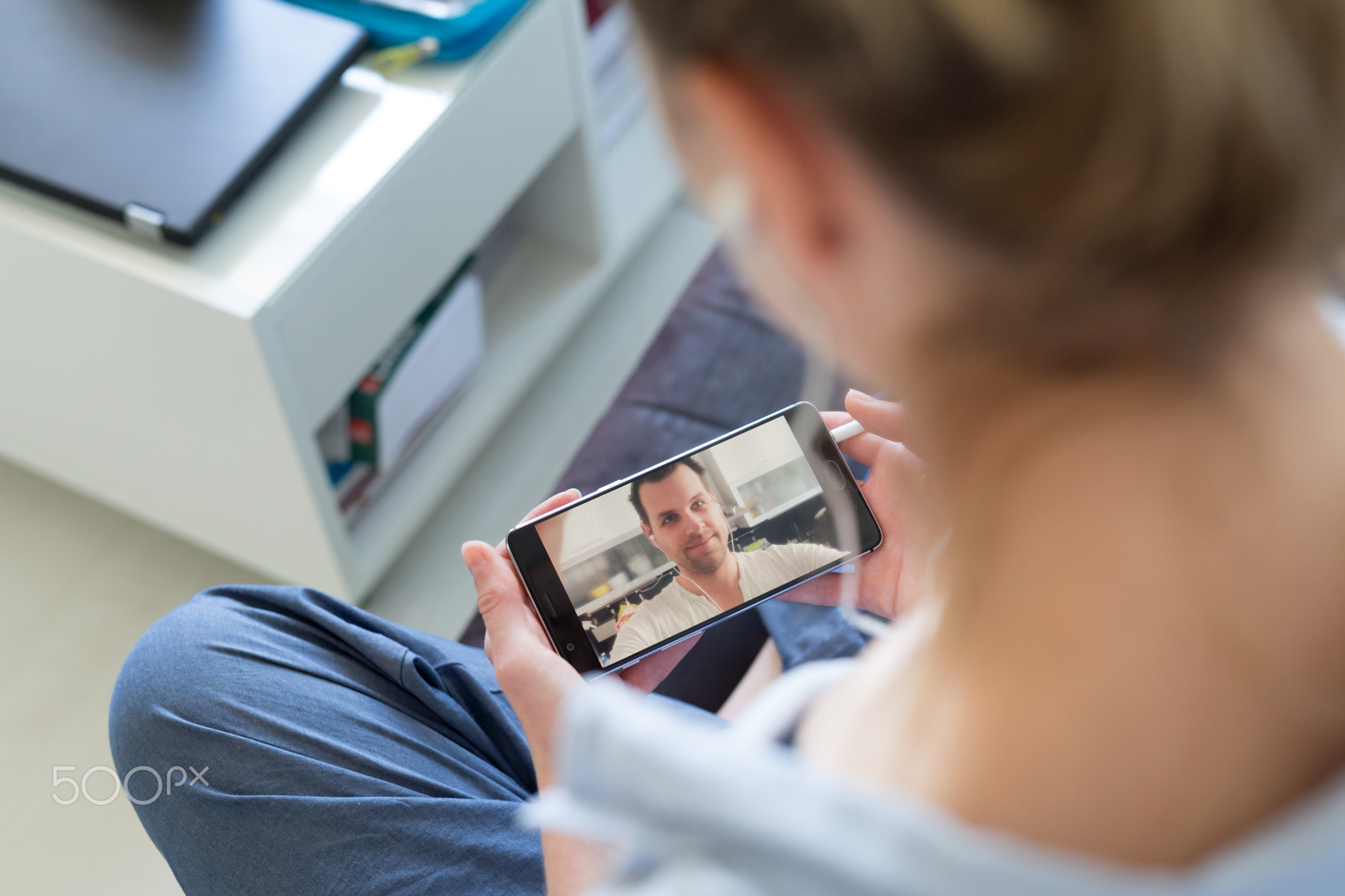 Woman at home relaxing on sofa couch using social media on phone for