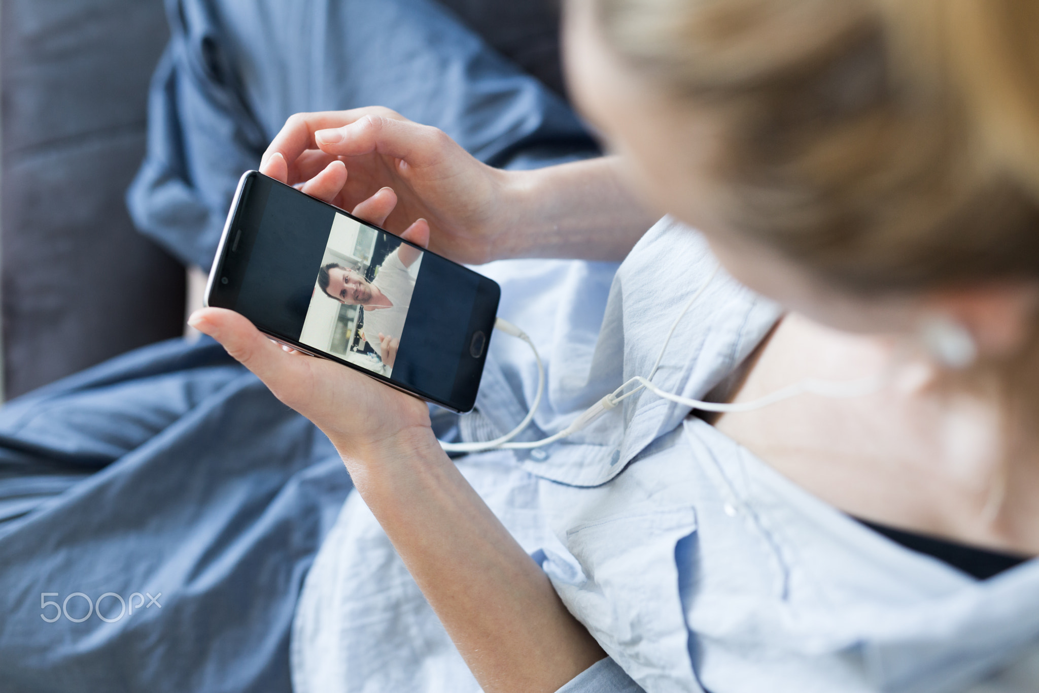 Woman at home relaxing on sofa couch using social media on phone for