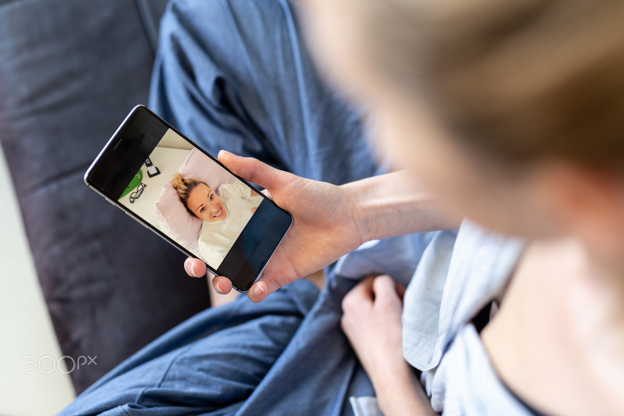 Woman at home relaxing on sofa couch using social media on phone for