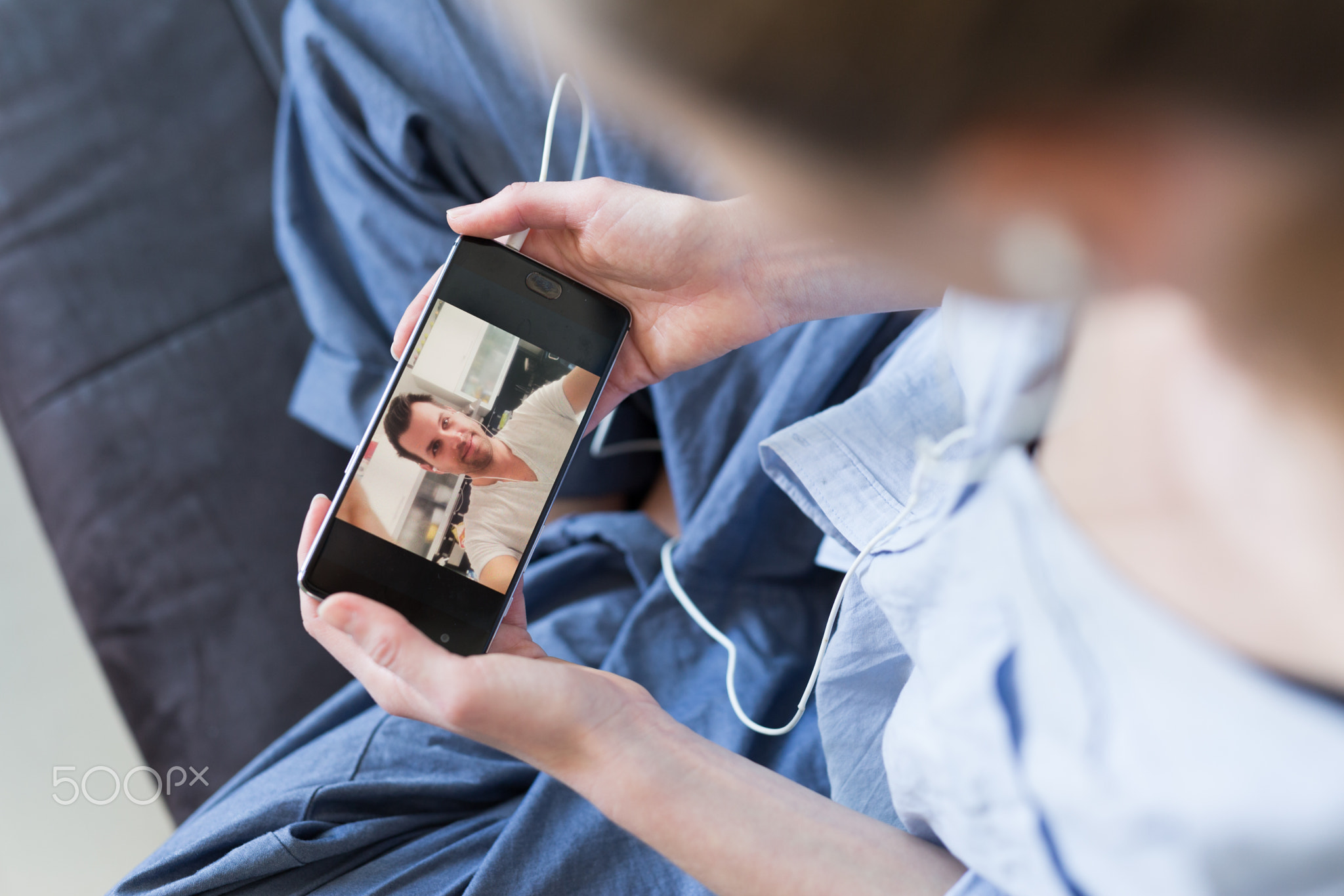 Woman at home relaxing on sofa couch using social media on phone for