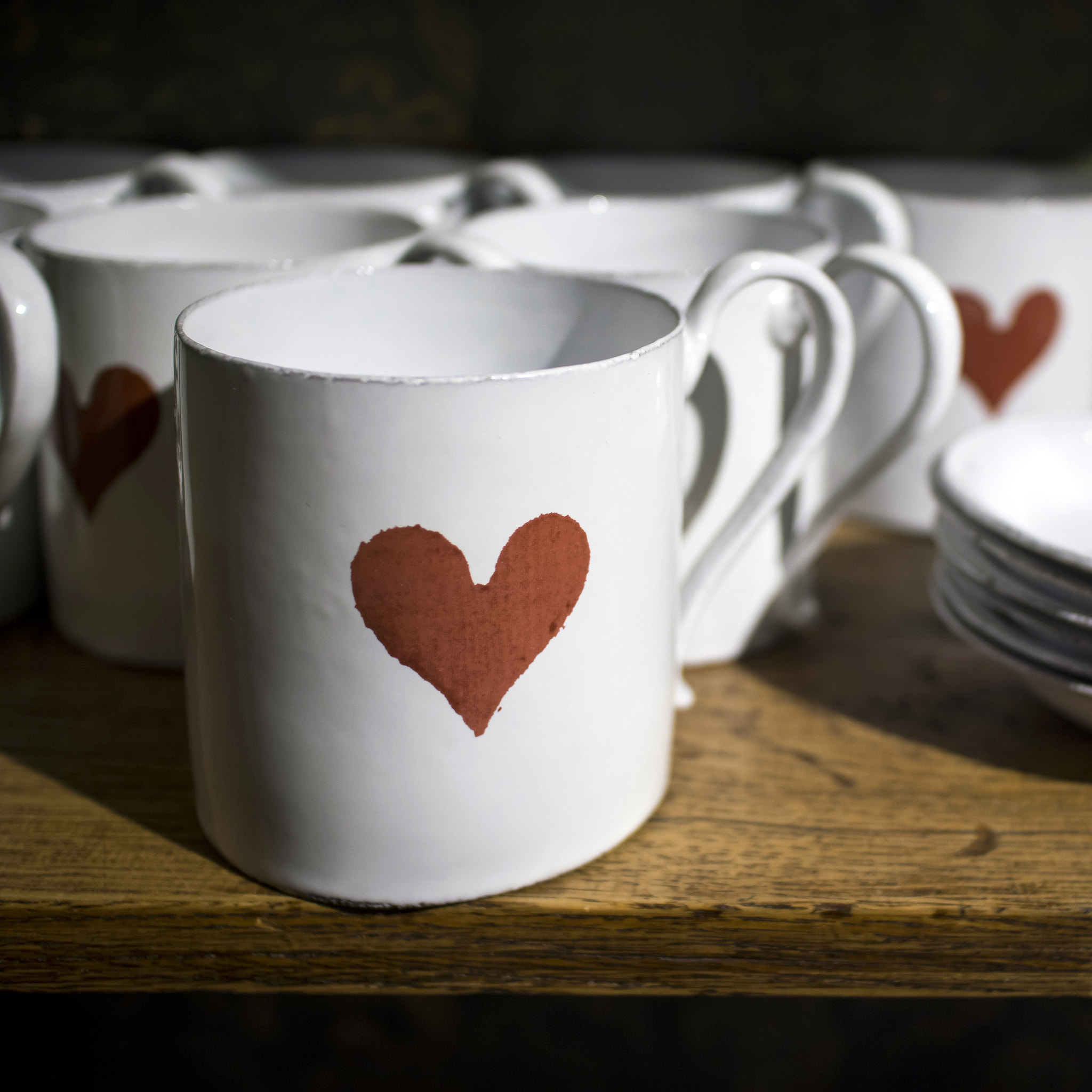 White porcelain mugs and saucers with red heart print