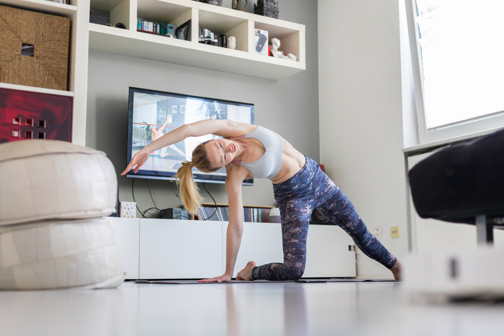 Attractive sporty woman working out at home, doing pilates exercise in by Matej Kastelic on 500px.com