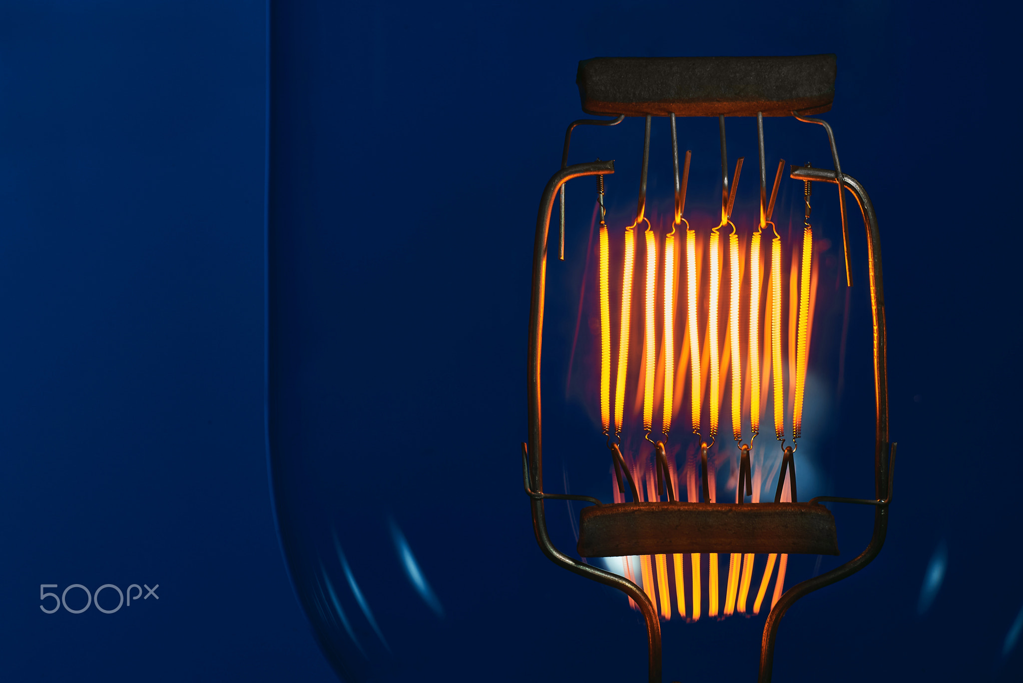 tungsten filament of high power incandescent lamp on blue background