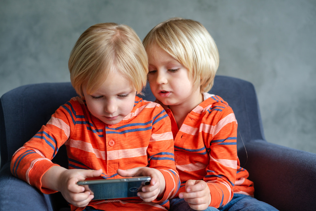 Brothers are watching or playing or learning something in a smartphone by ????? ????????? on 500px.com