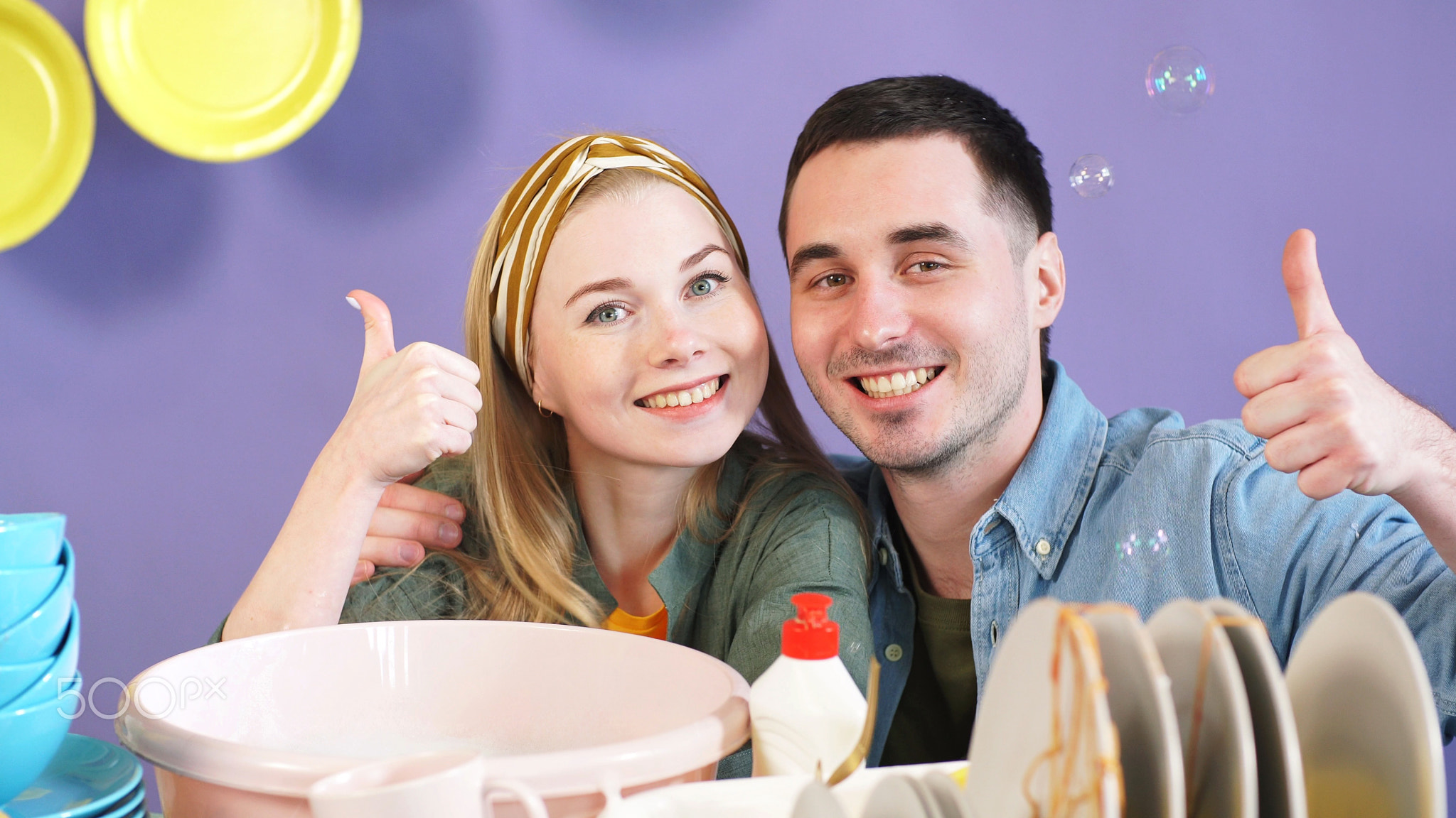 Positive young woman and a black-haired man give a thumbs up while