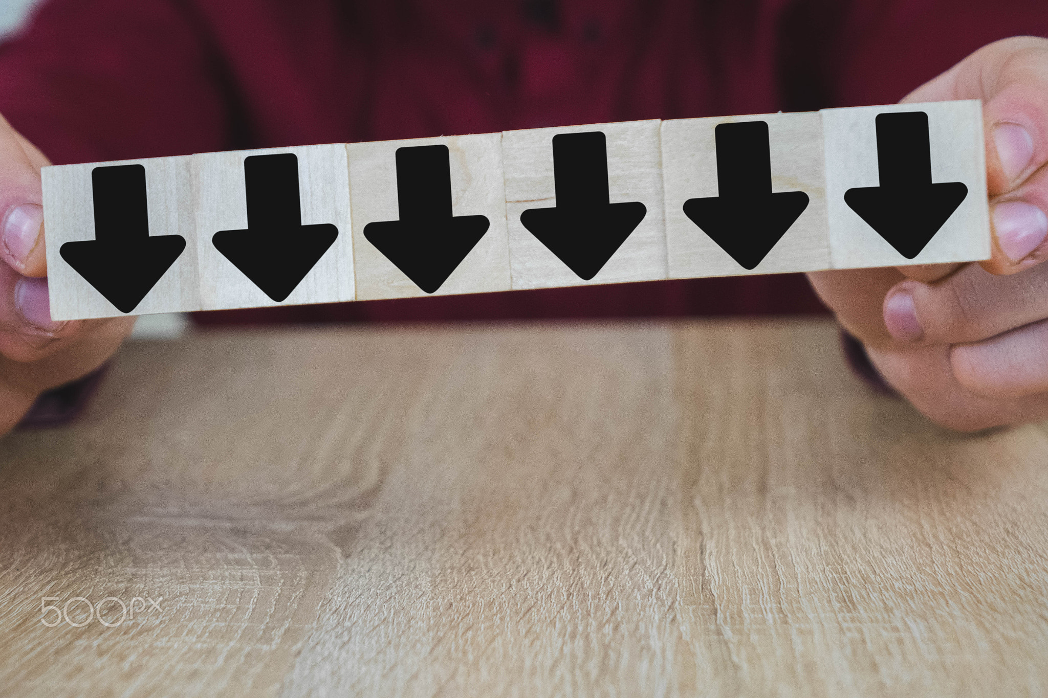 a person pulls one of the wooden cubes standing on the table, all of