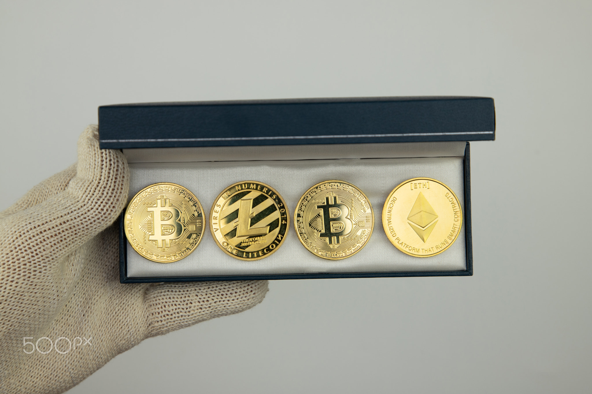 cryptocurrencies in a box in a man’s hand, top view, close-up, glove