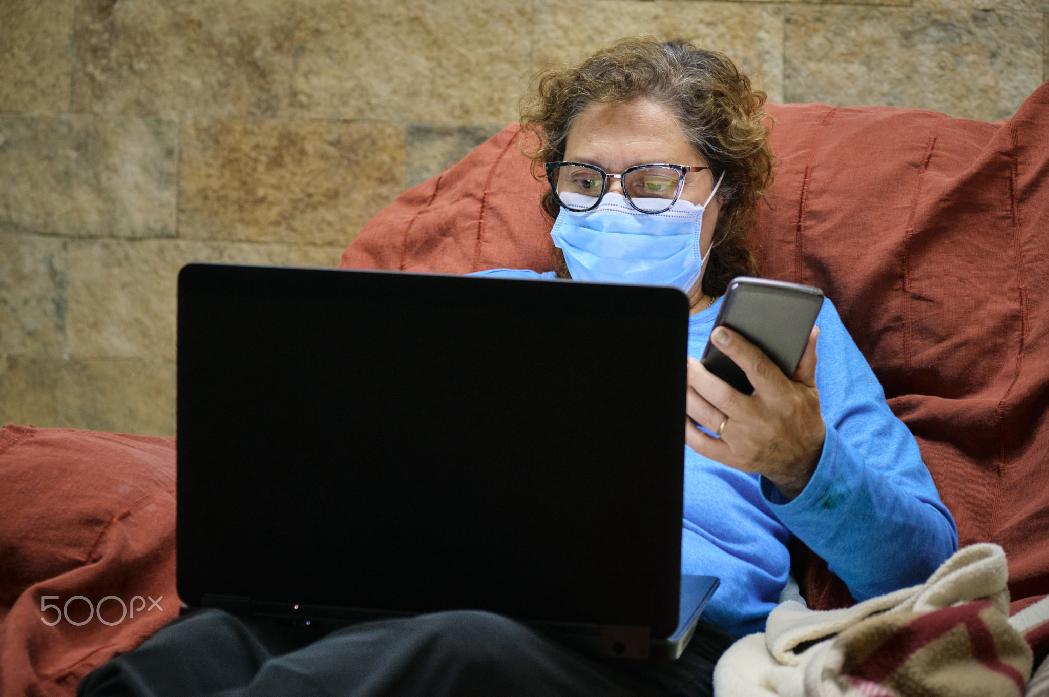 a woman physician homeworking with a face mask