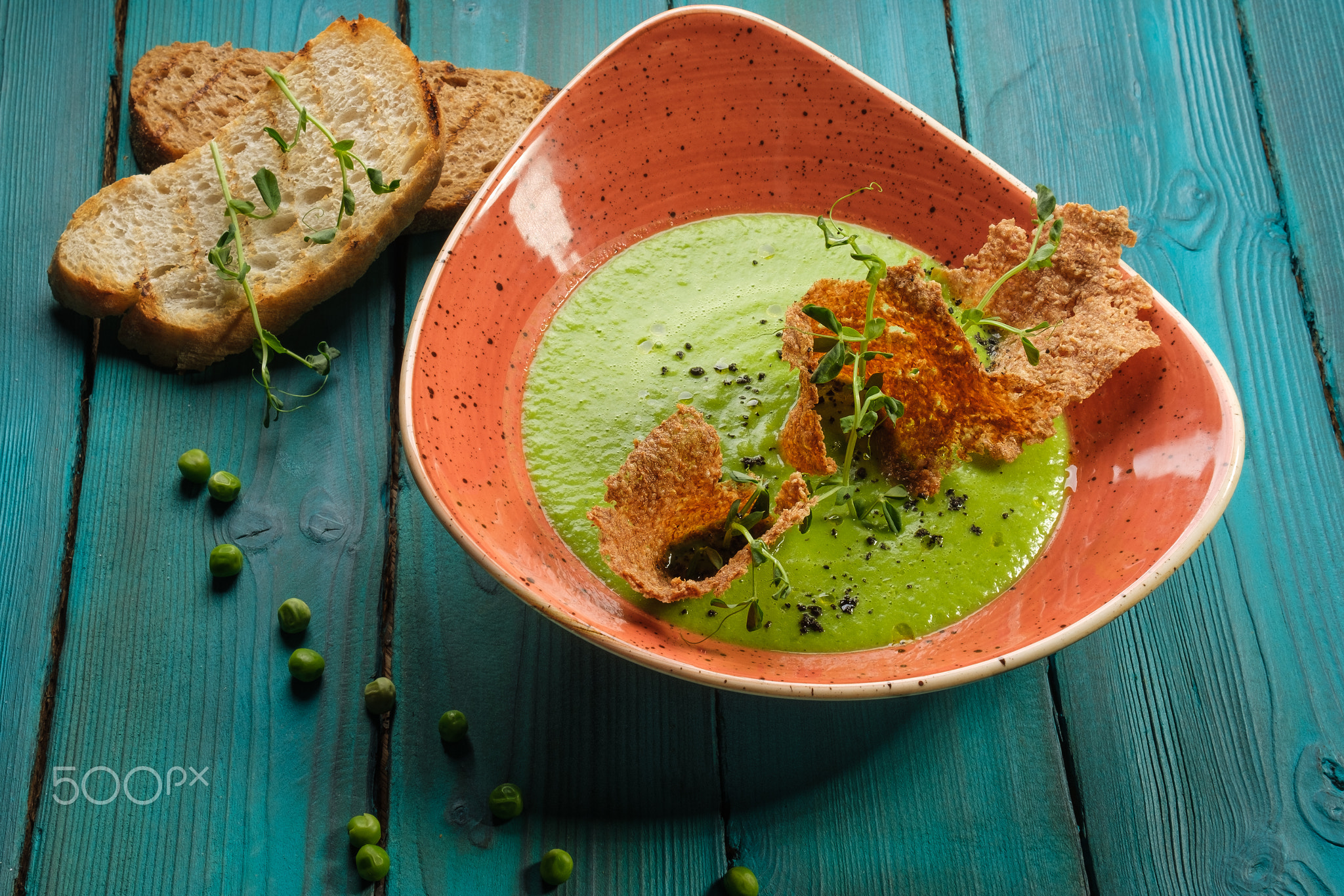 Cream of green pea soup decorated with edible chips