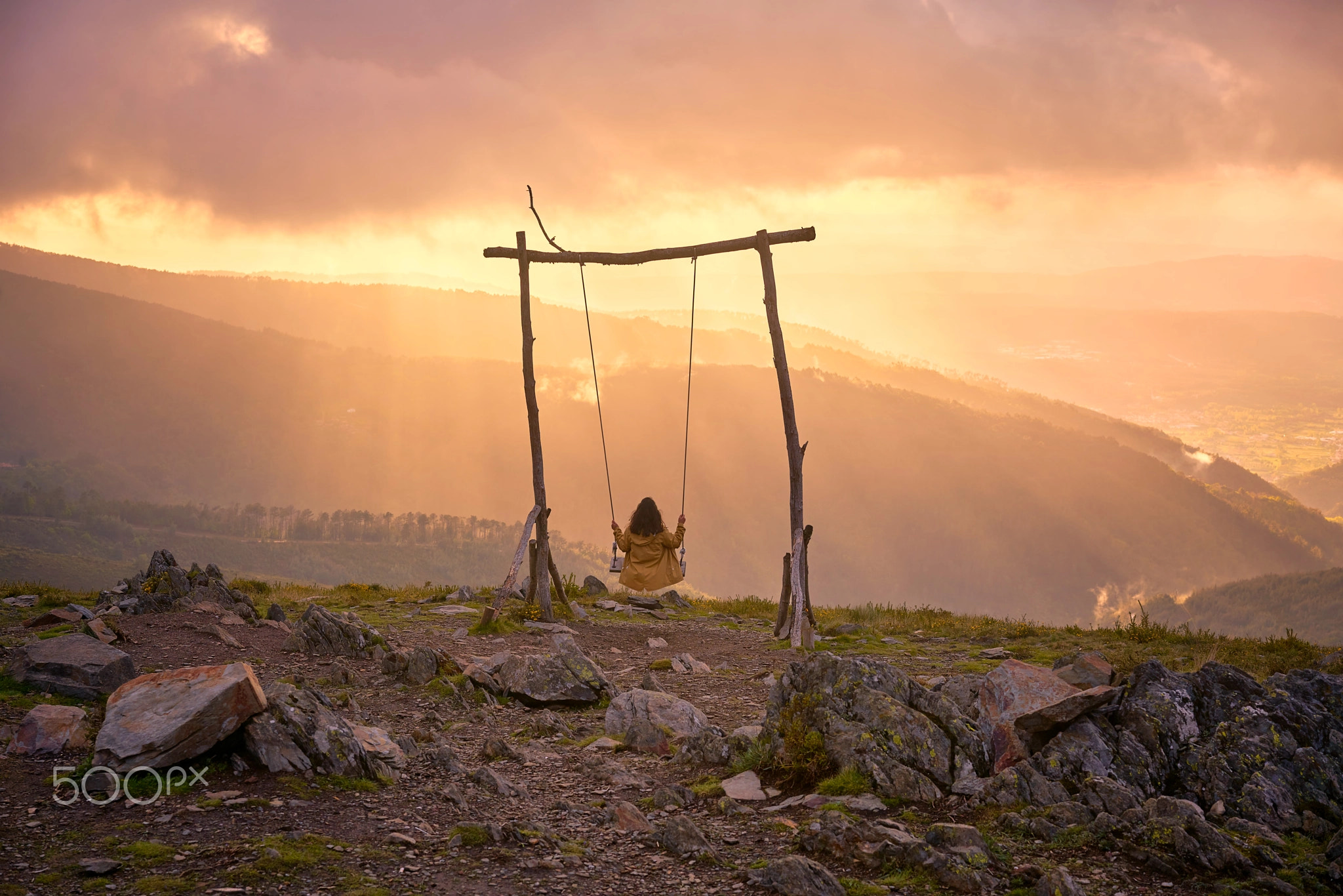 Woman girl swinging on a Swing in Lousa mountain, Portugal at sunset