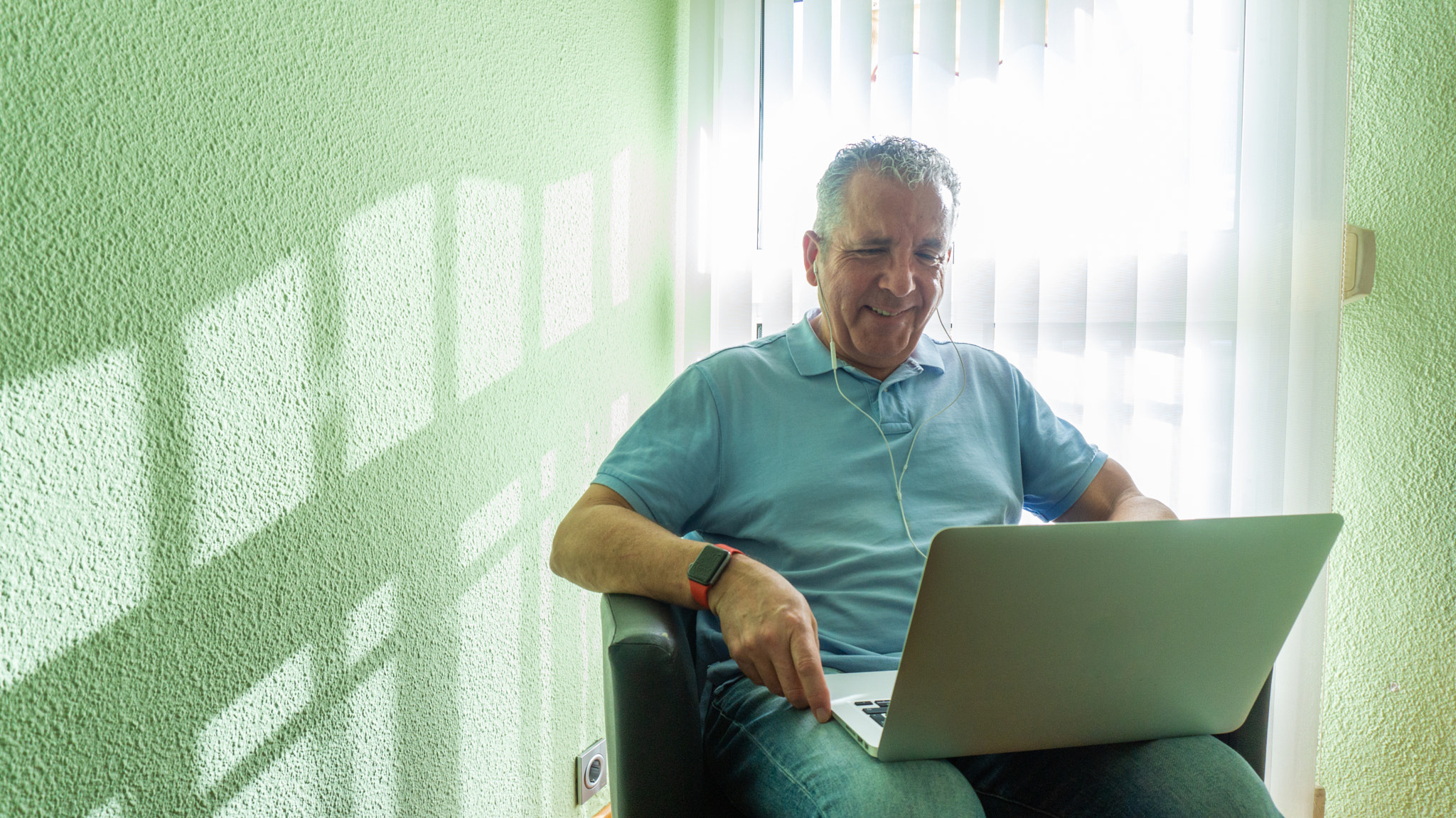 Caucasian male smiling and use laptop to work