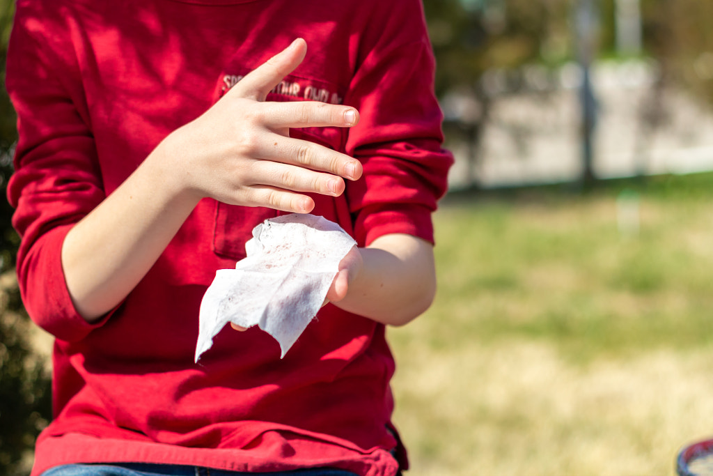 the kid in red t-shirt clean his hands with antibacterial wipe by Irina K on 500px.com