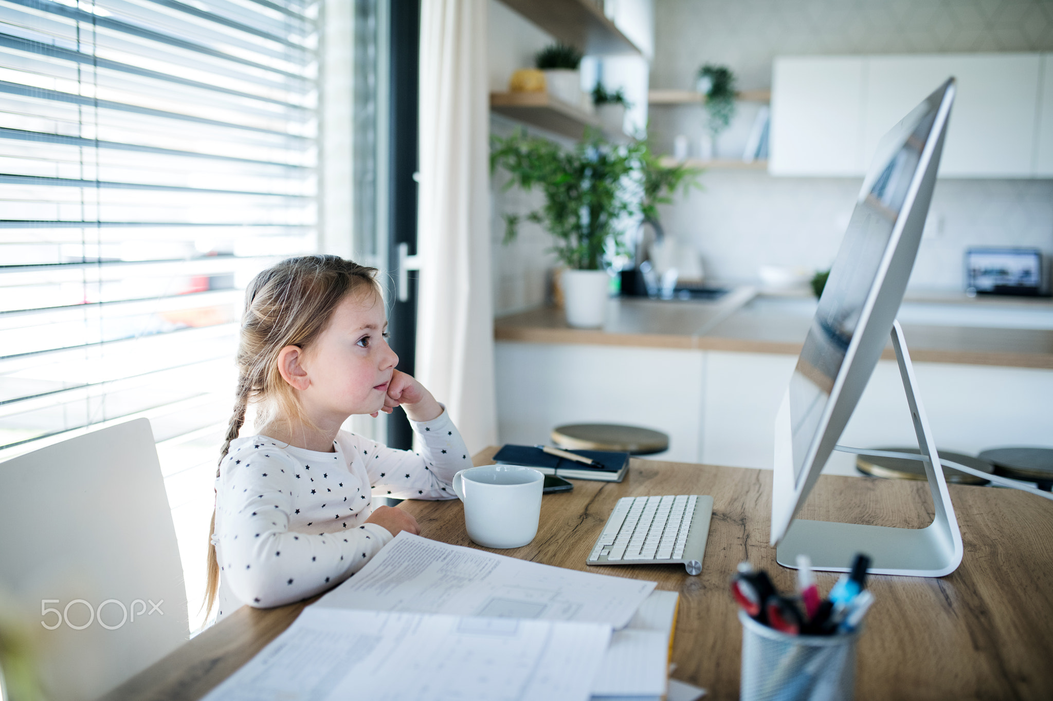 Small girl watching story on computer indoors at home, Corona virus