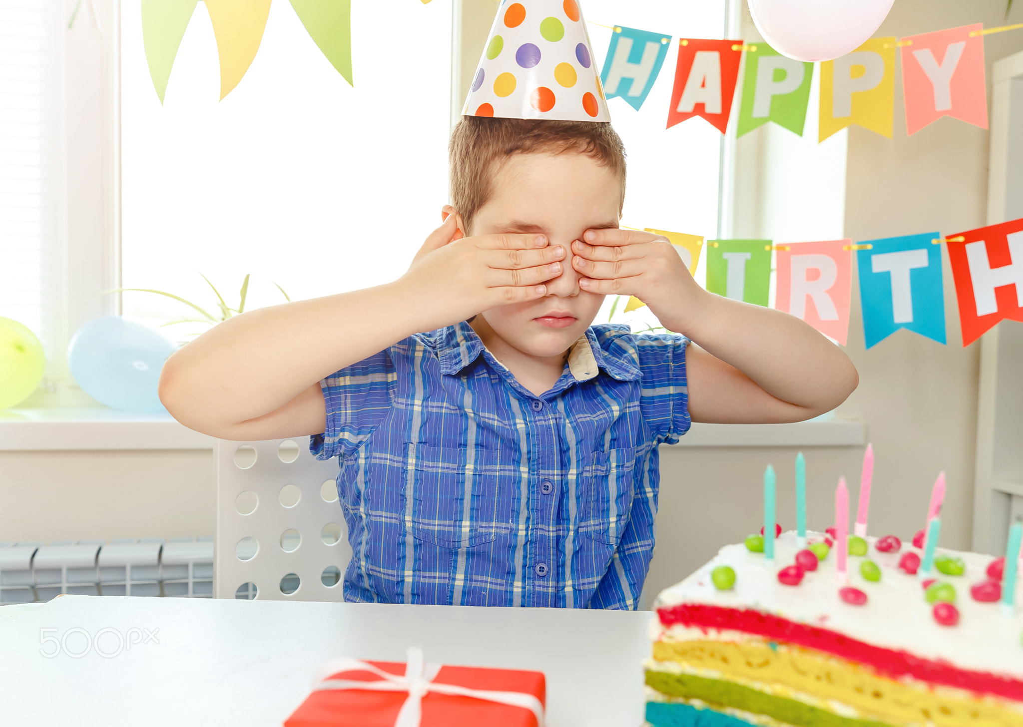 Cute boy surprised birthday cake. Child celebrates her birthday alone