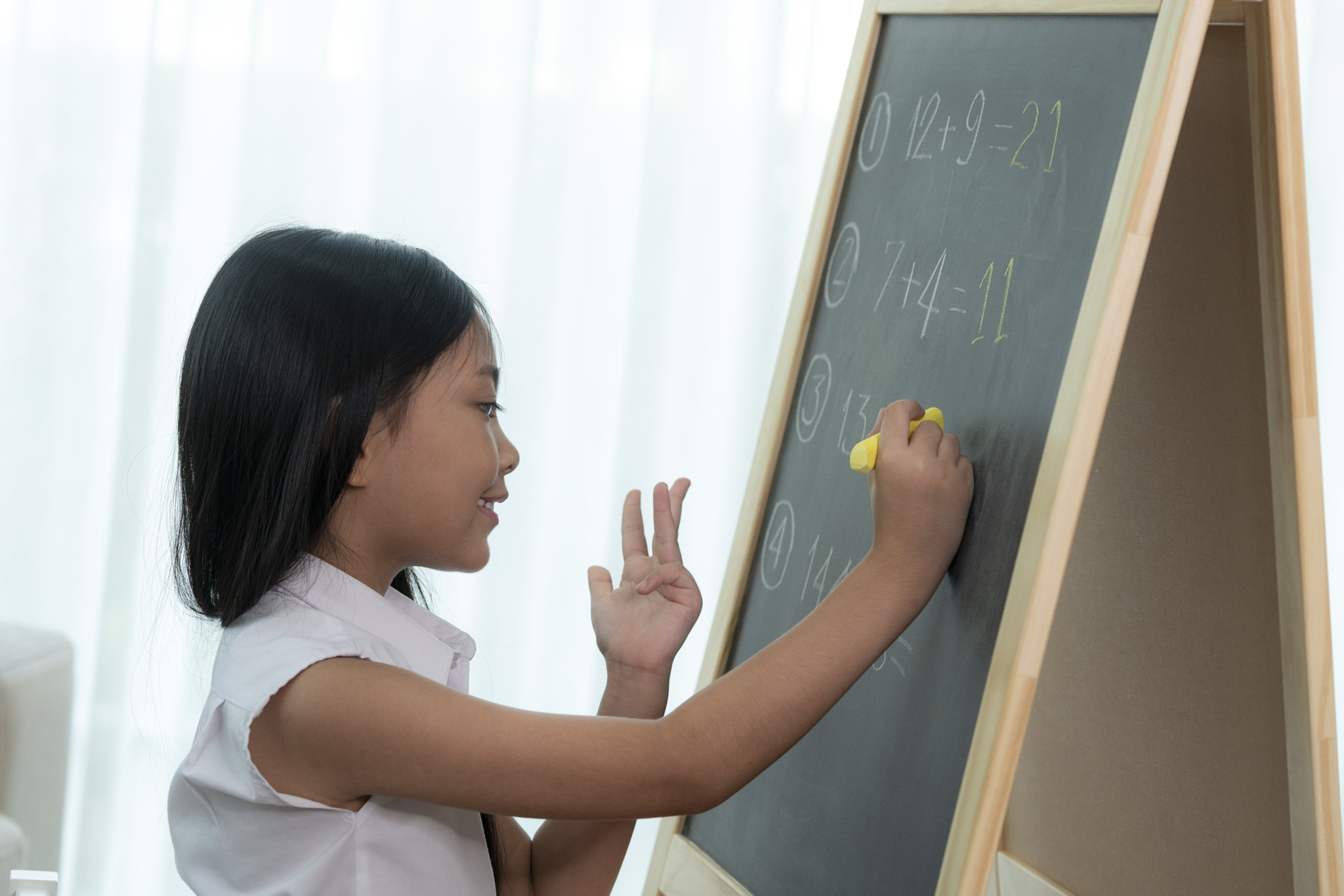 Asian girl write and do home work on the backboard