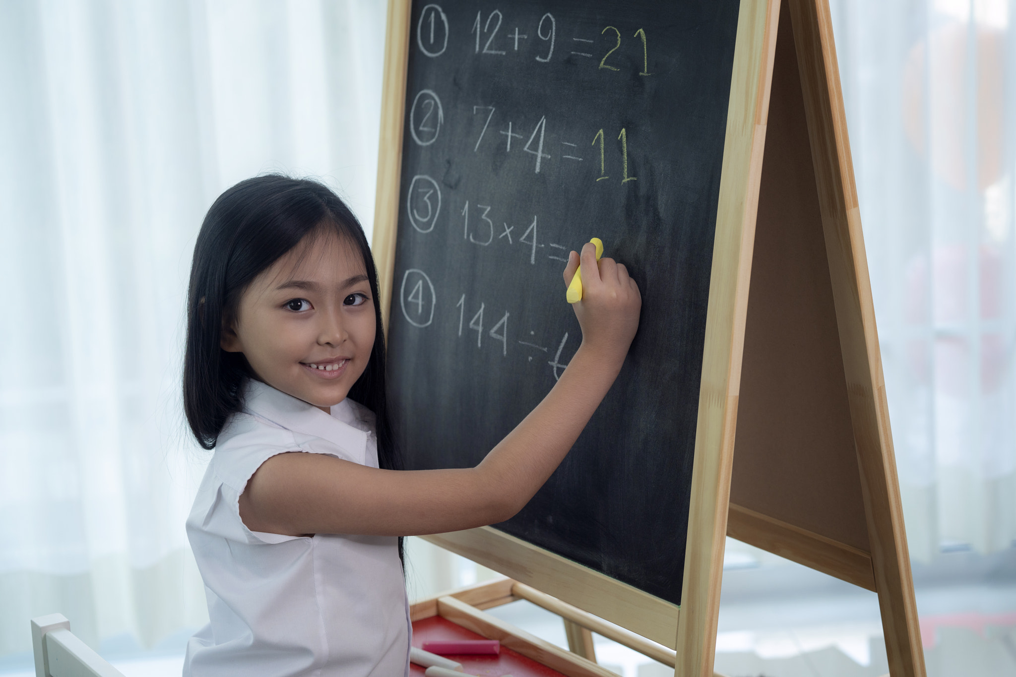Asian girl write and do home work on the backboard