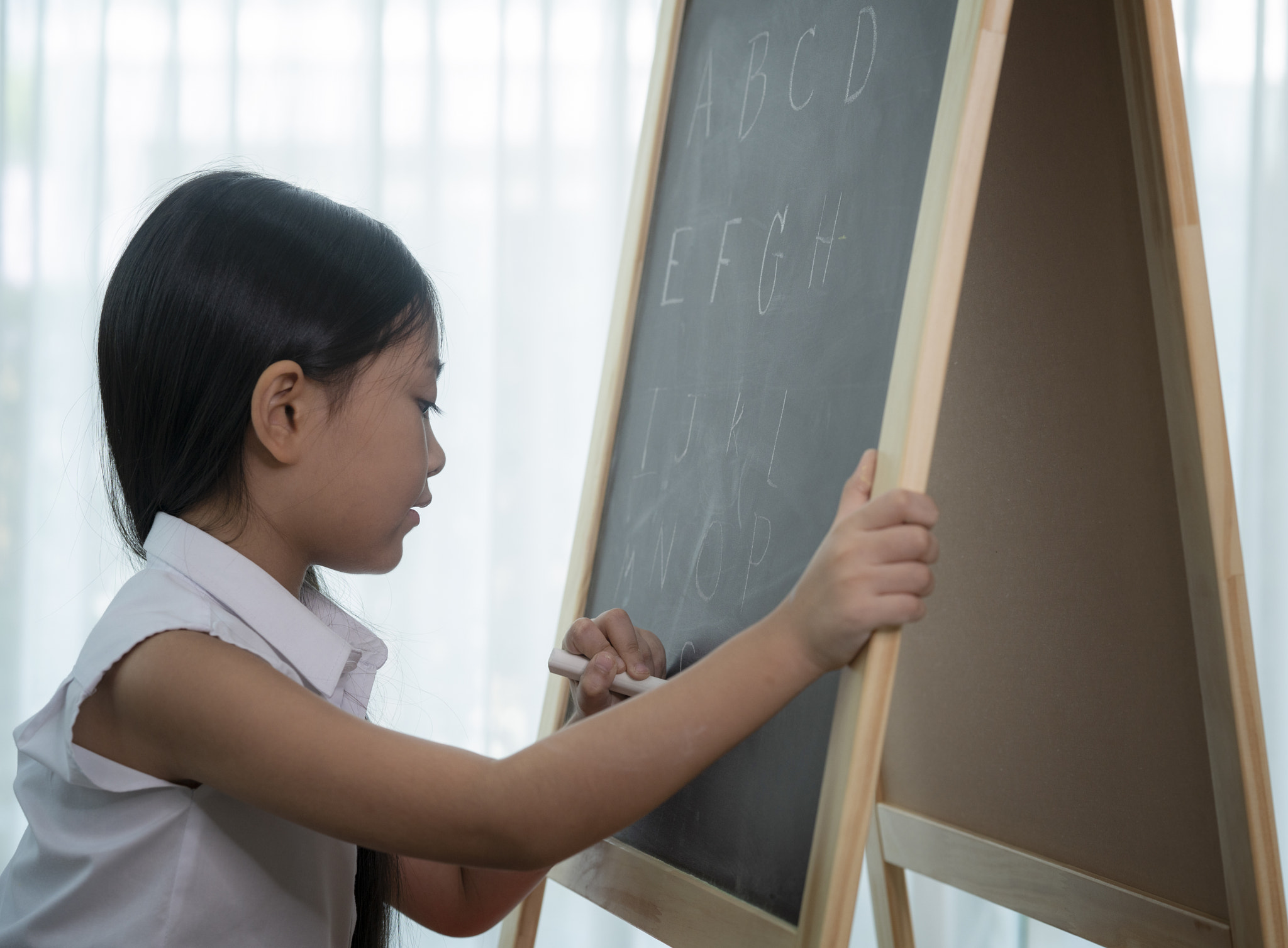 Asian girl write and do home work on the backboard