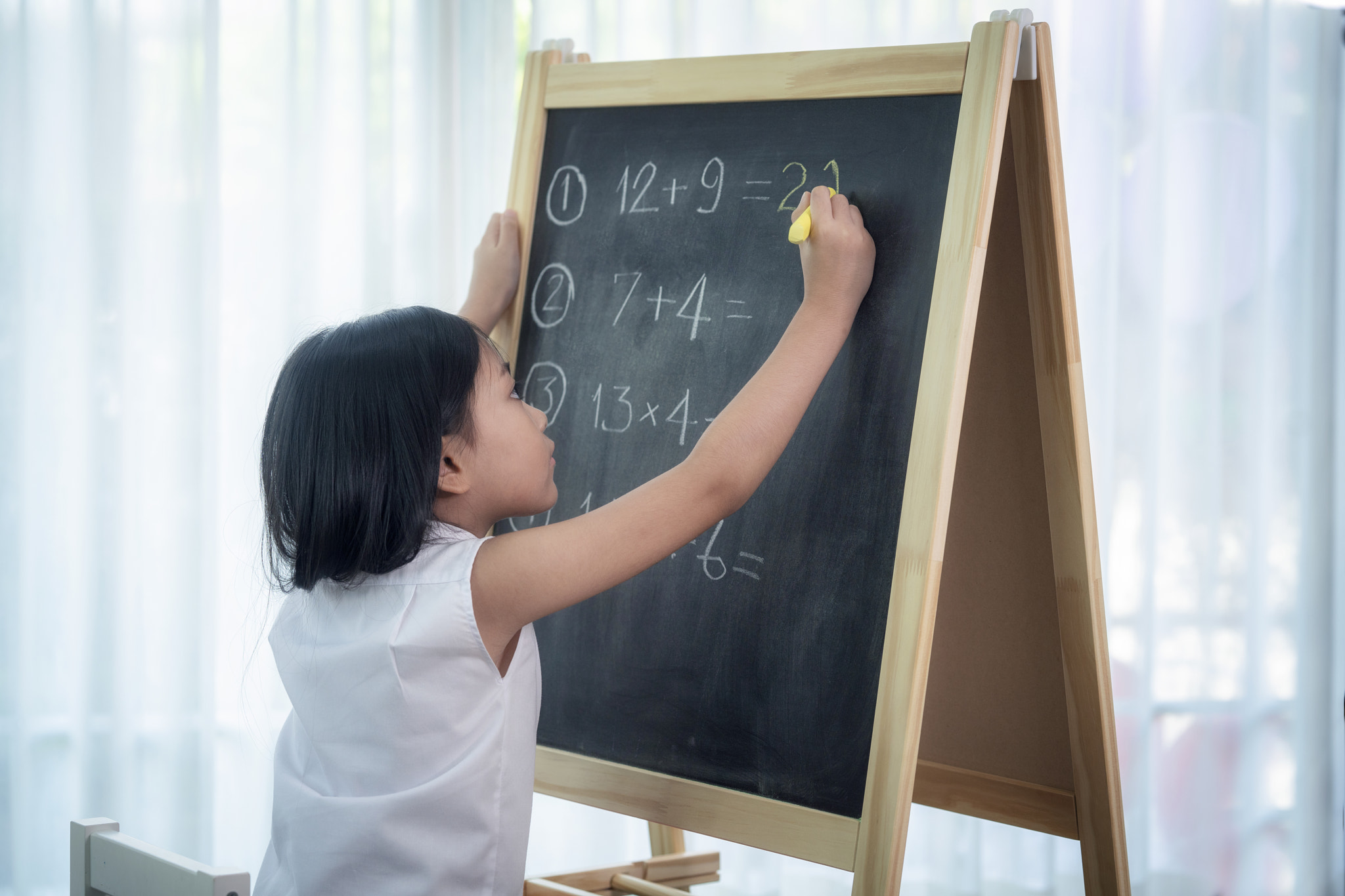 Asian girl write and do home work on the backboard