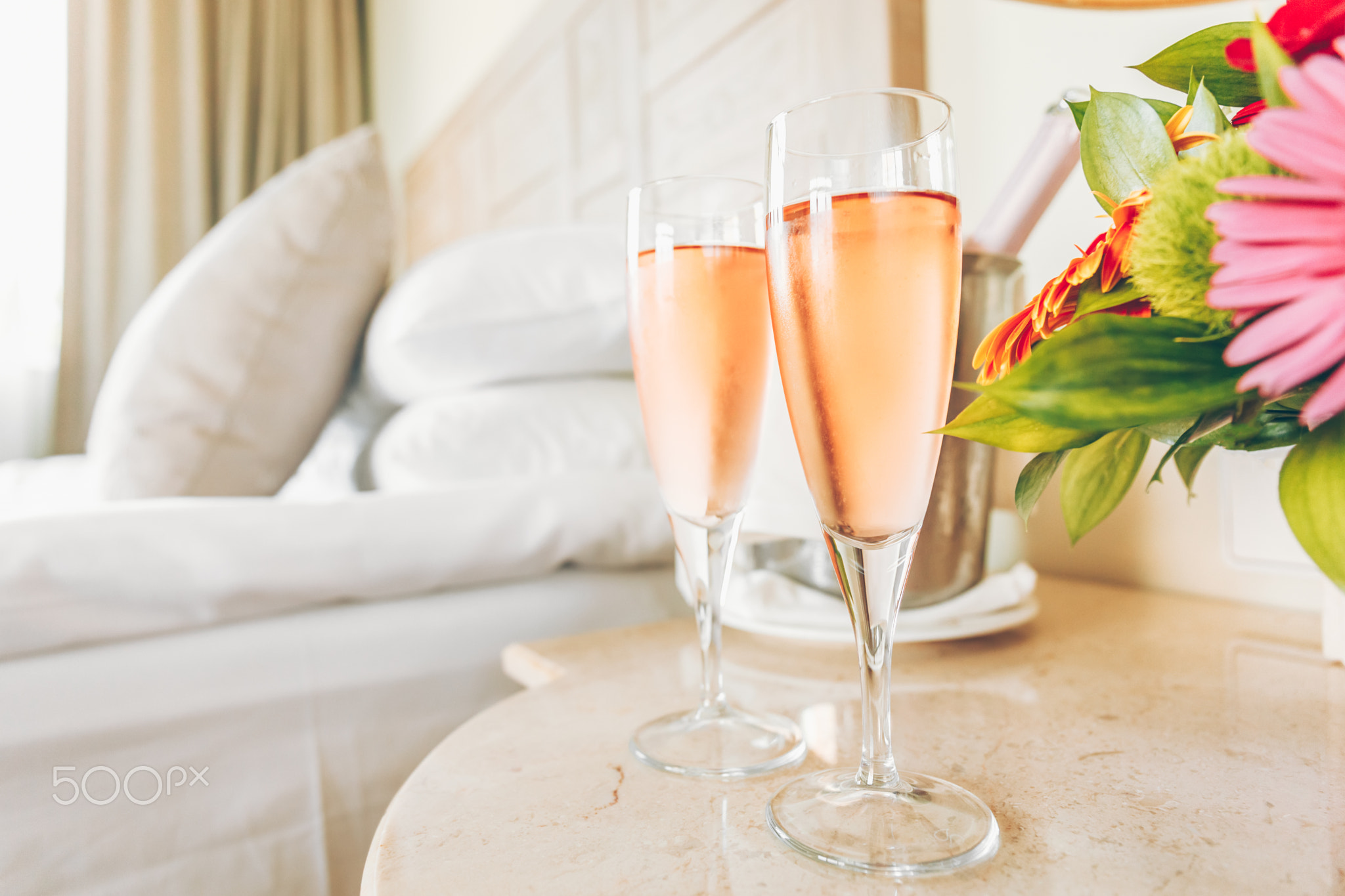 Two glasses of rose champagne in the upscale hotel room. Dating
