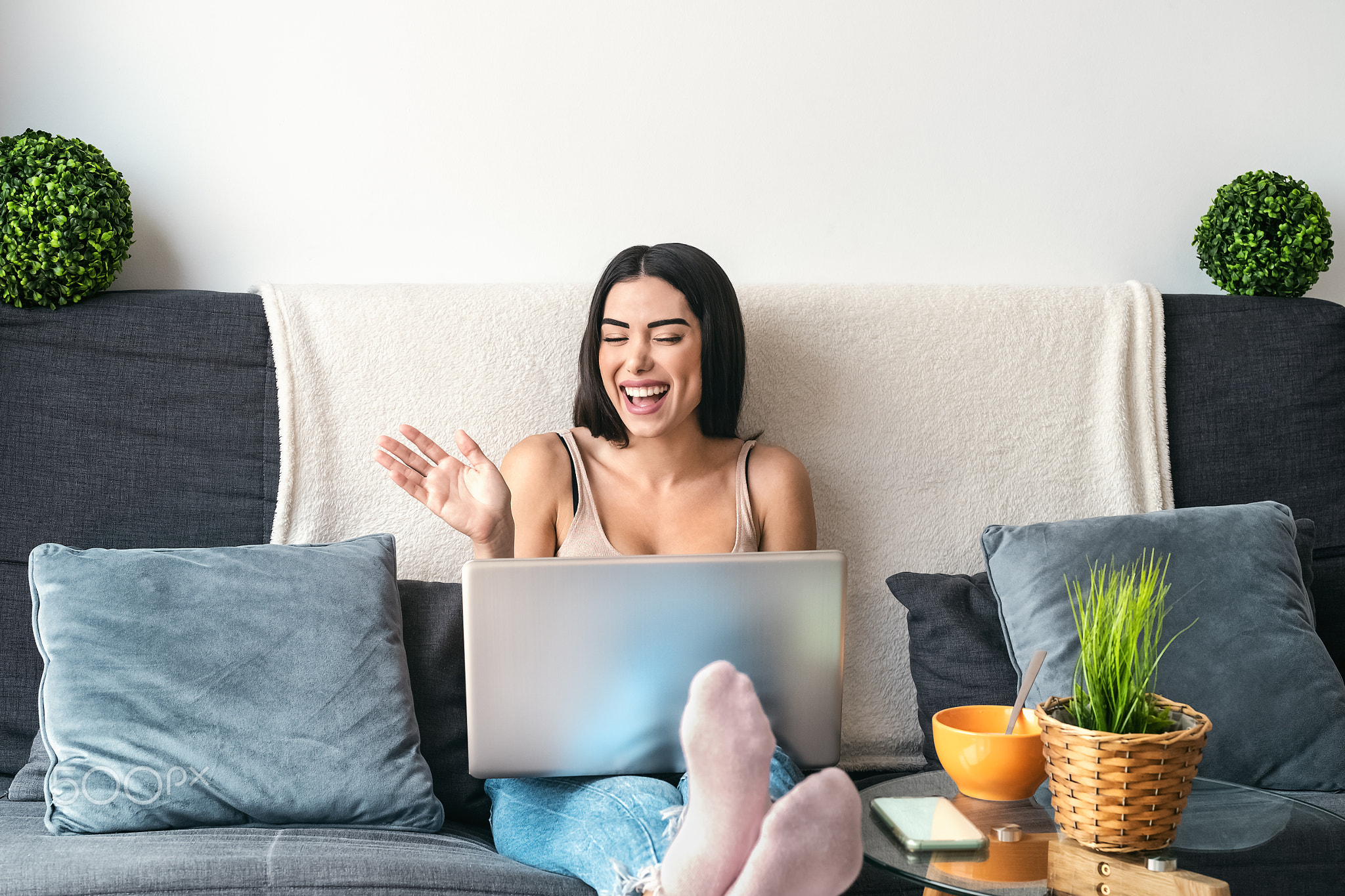 Young woman making video call sitting on sofa