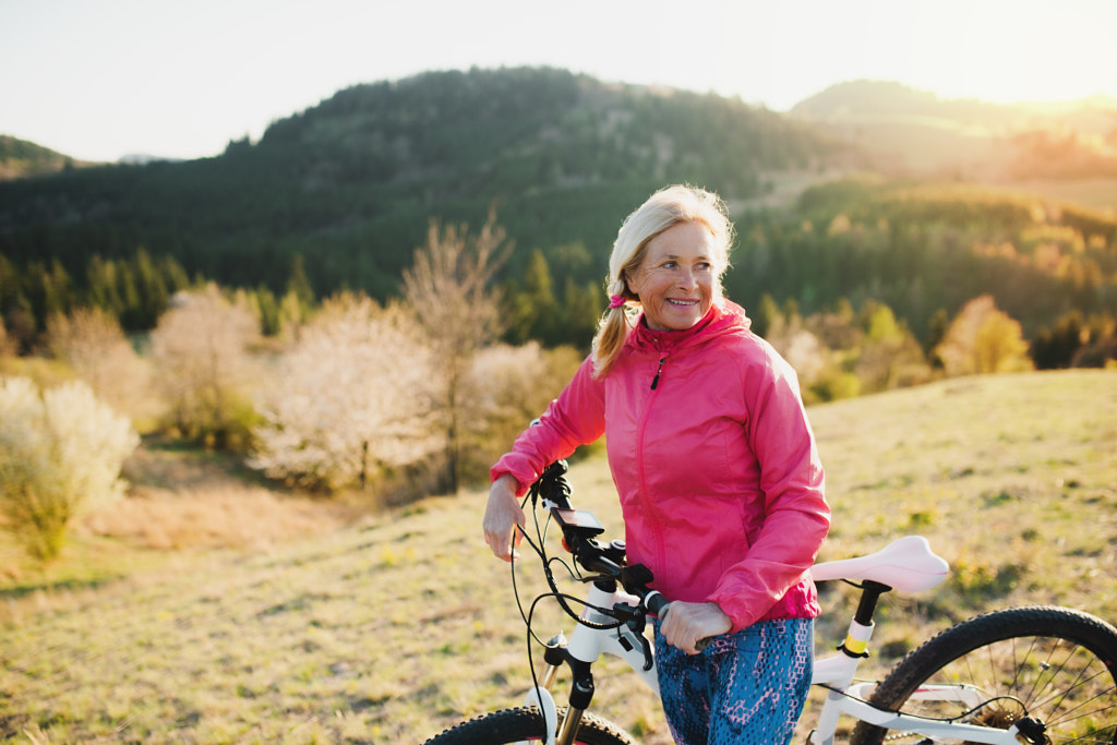 Active senior woman with bicycle outdoors in nature, resting. by Jozef Polc on 500px.com