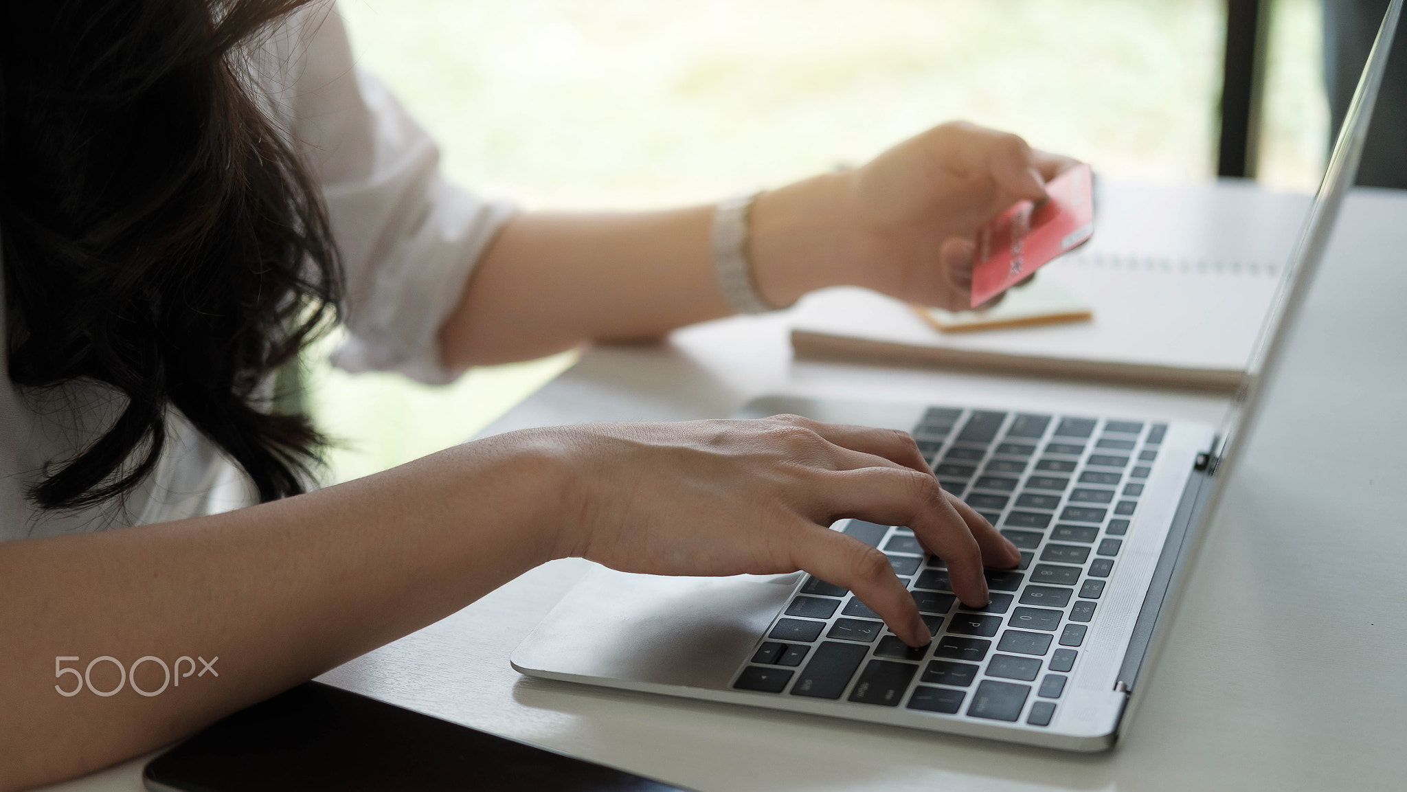 Woman using laptop computer for online shopping purchase with credit