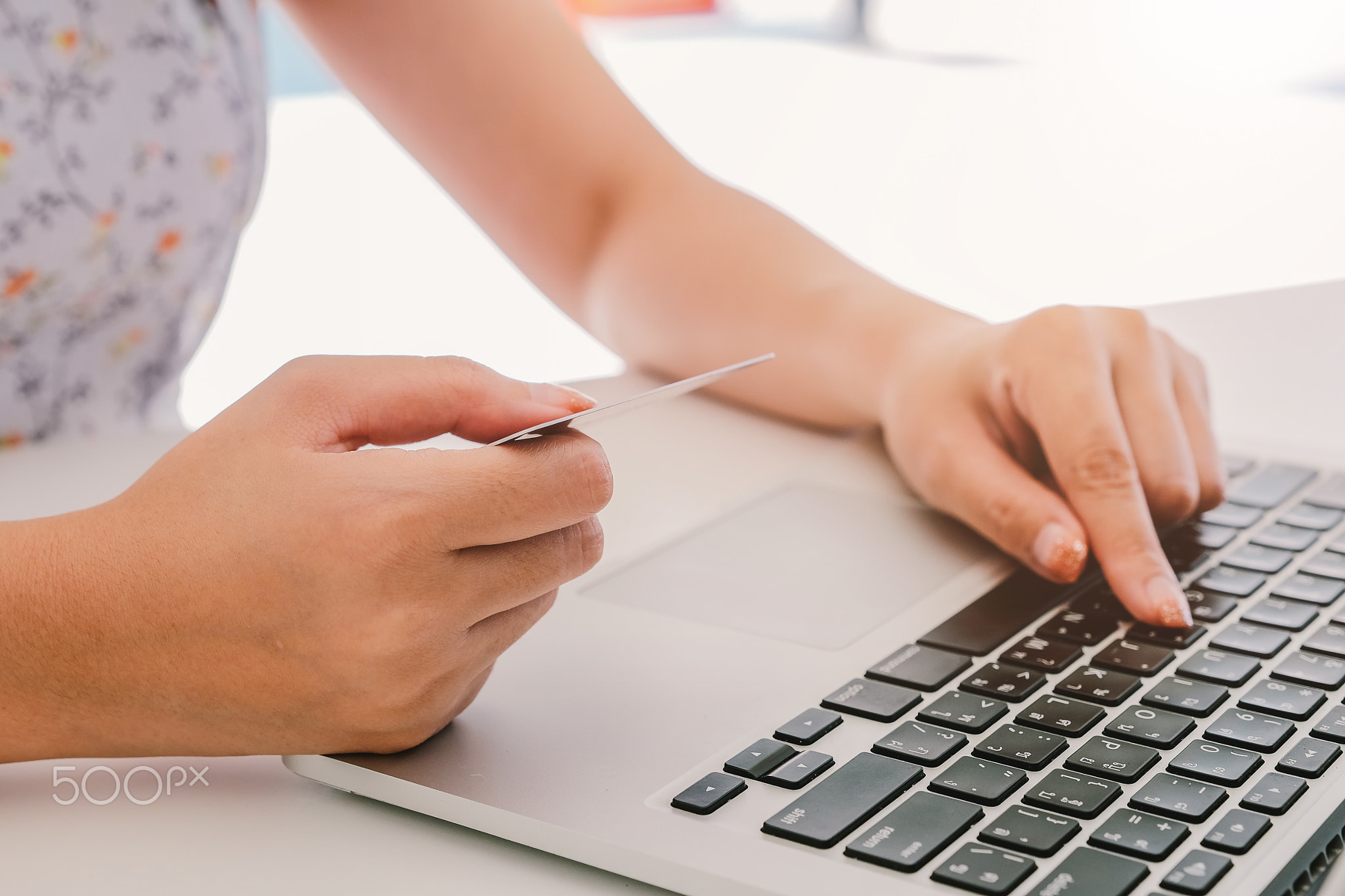 Close up hand of woman using laptop computer and holding credit card