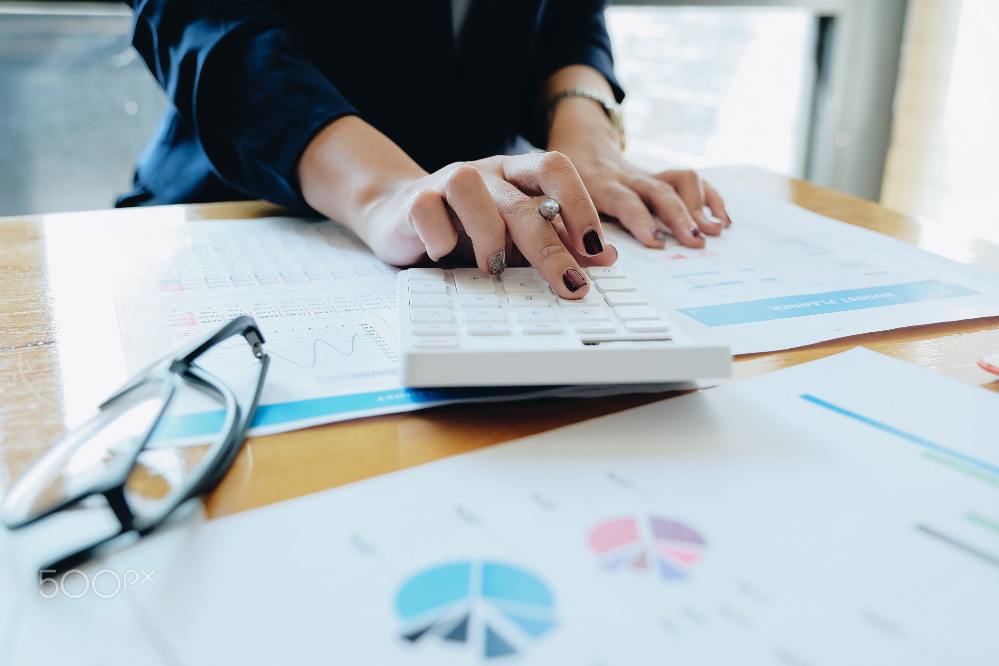 Close up Businesswoman using calculator and laptop for do math finance