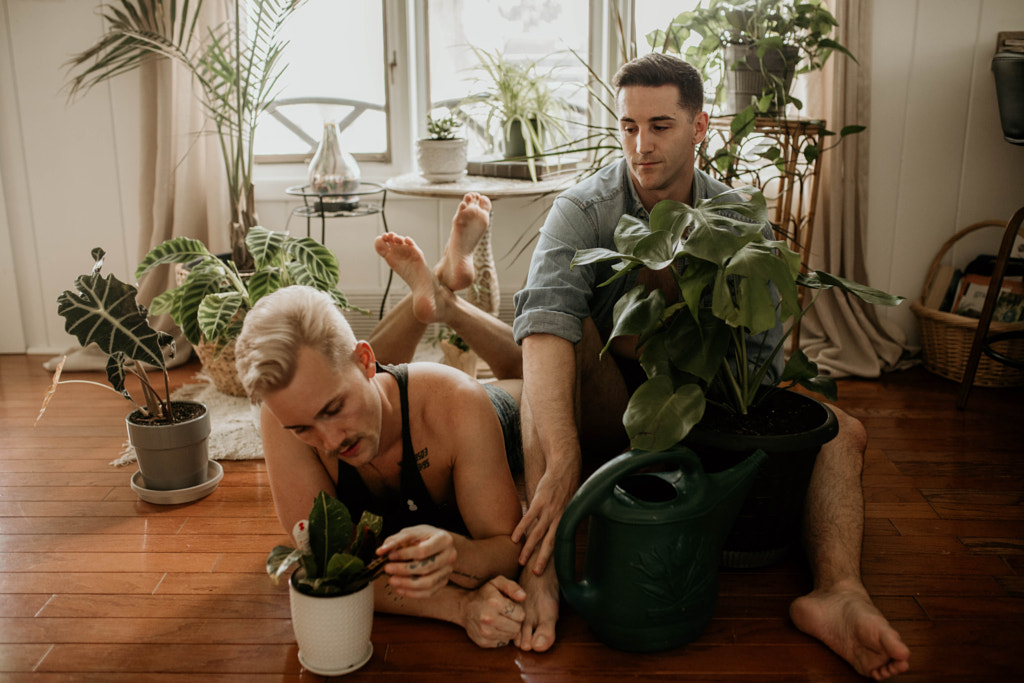 Two adult LGBTQ+ men caring for their houseplants by Kyle Kuhlman on 500px.com