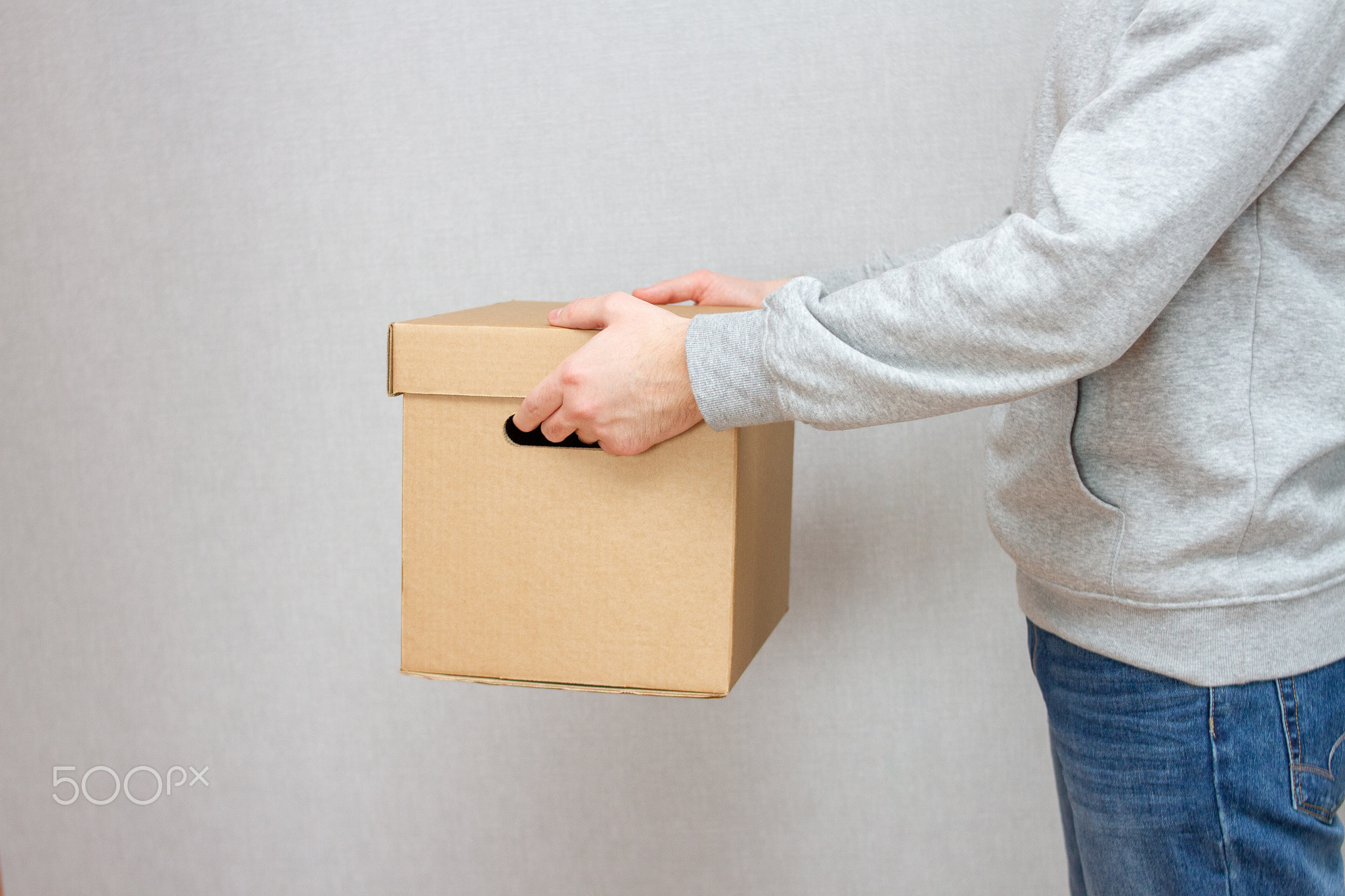 Delivery Man Holds Cardboard Box Package. Fast Delivery