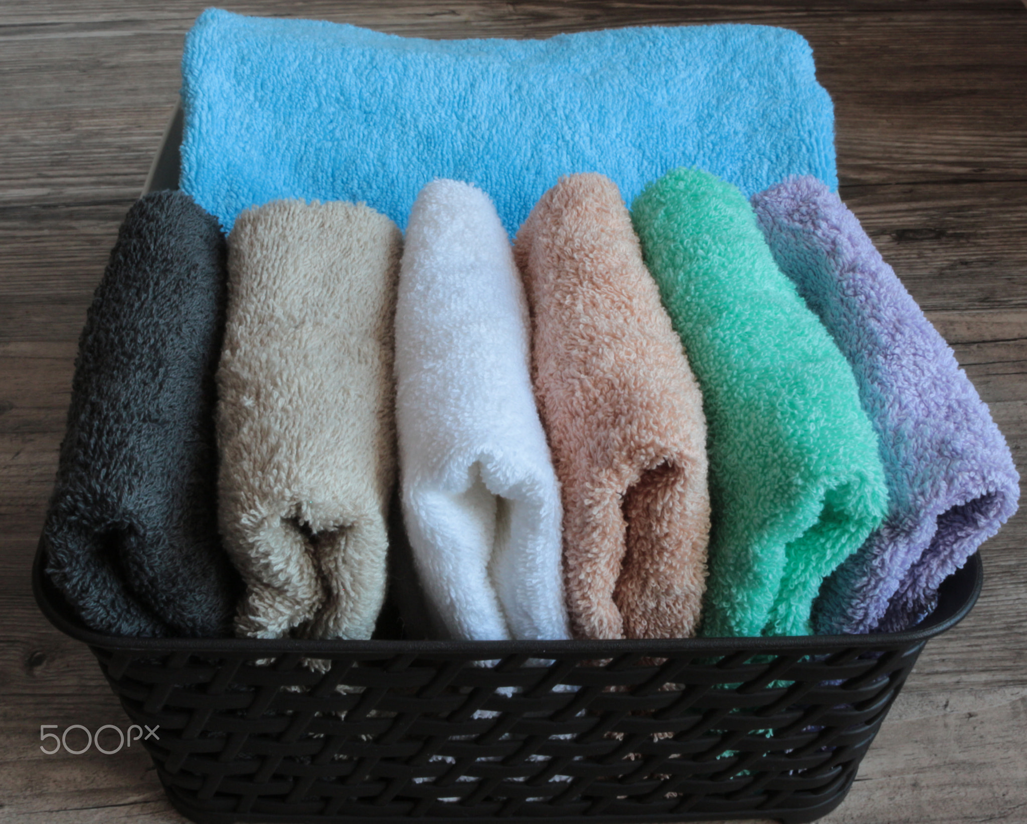 colorful towels in a basket on a wooden table