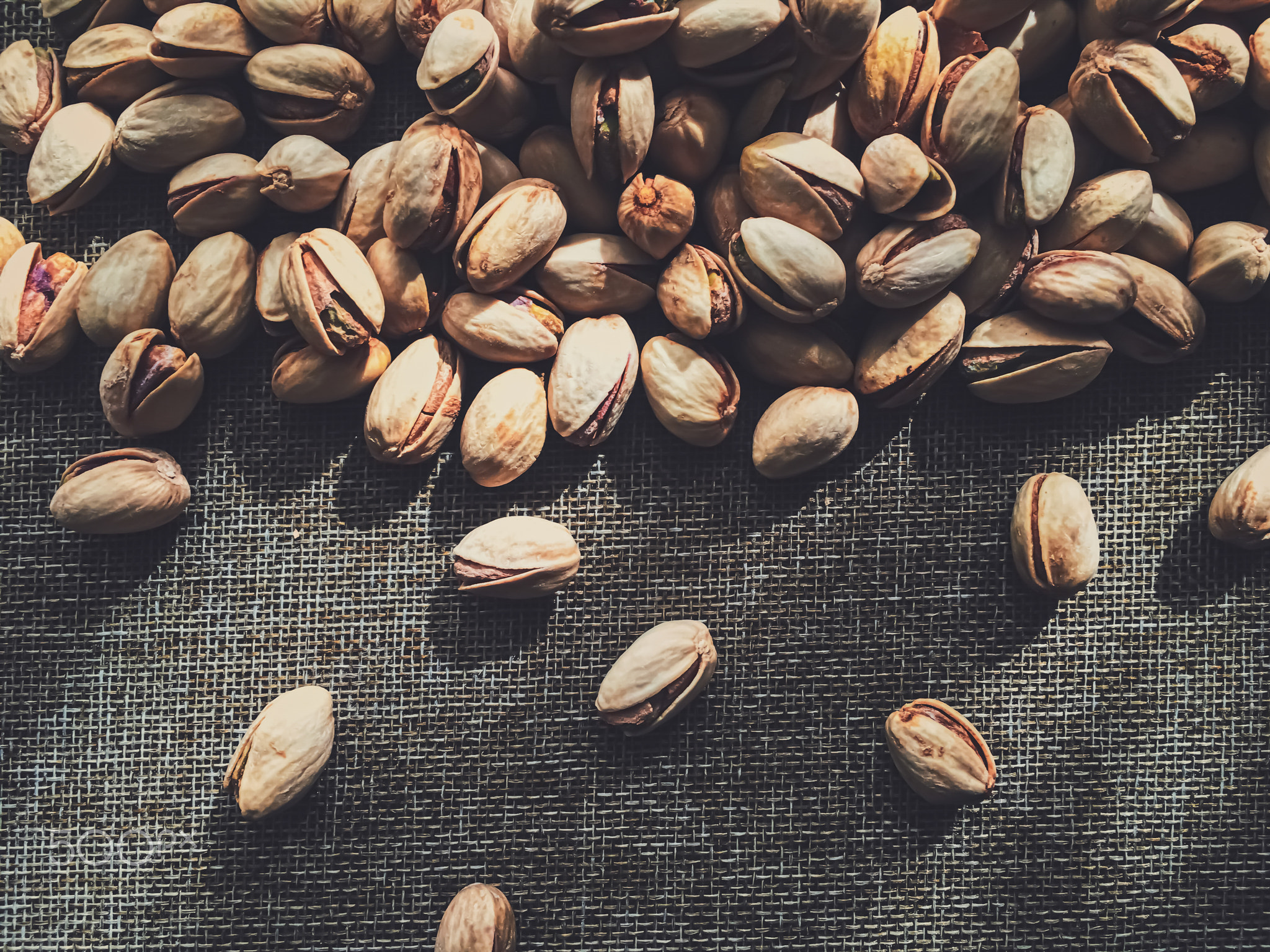 Pistachio nuts on rustic linen background