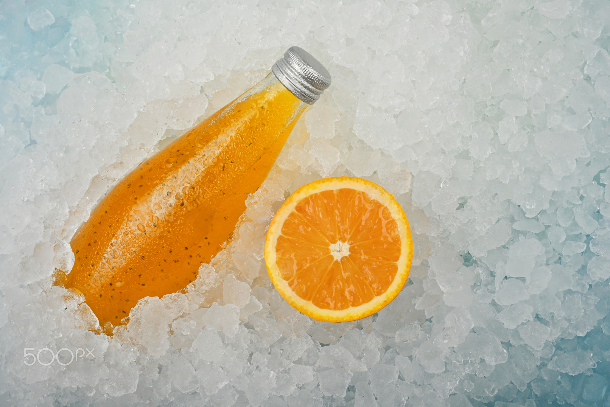 Bottle of orange drink on crushed ice