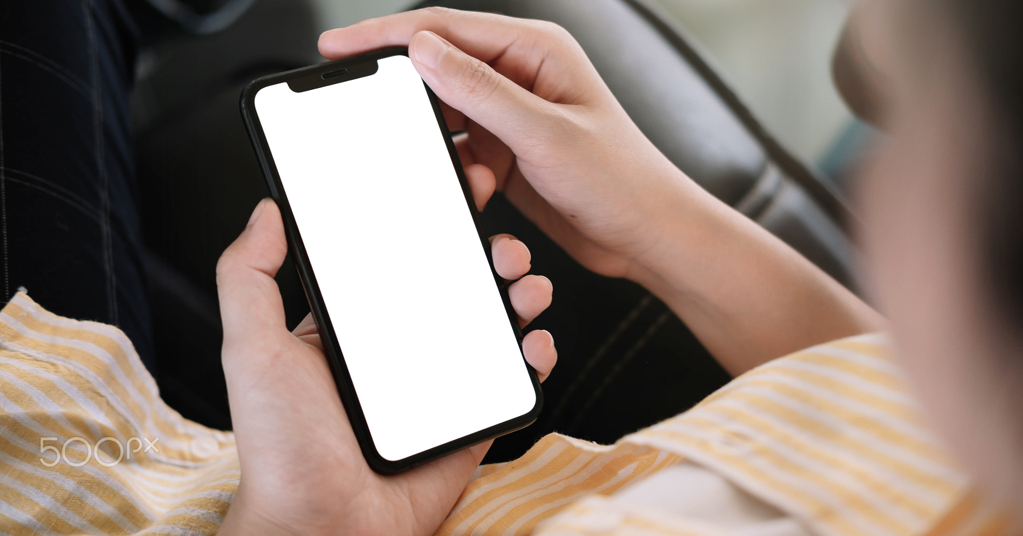 Woman sitting and holding blank screen mock up mobile phone