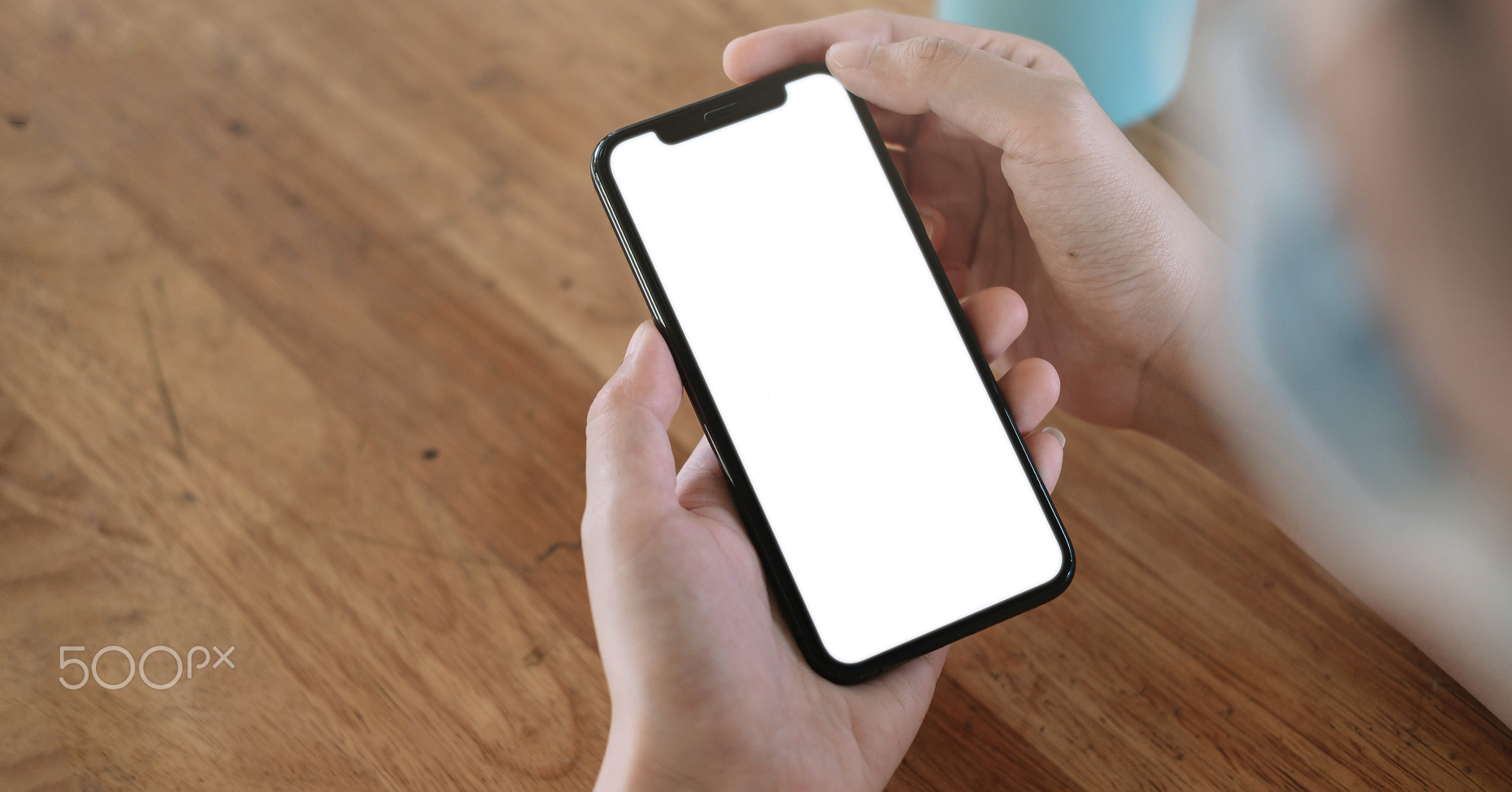 Top view Woman sitting and holding blank screen mock up mobile phone
