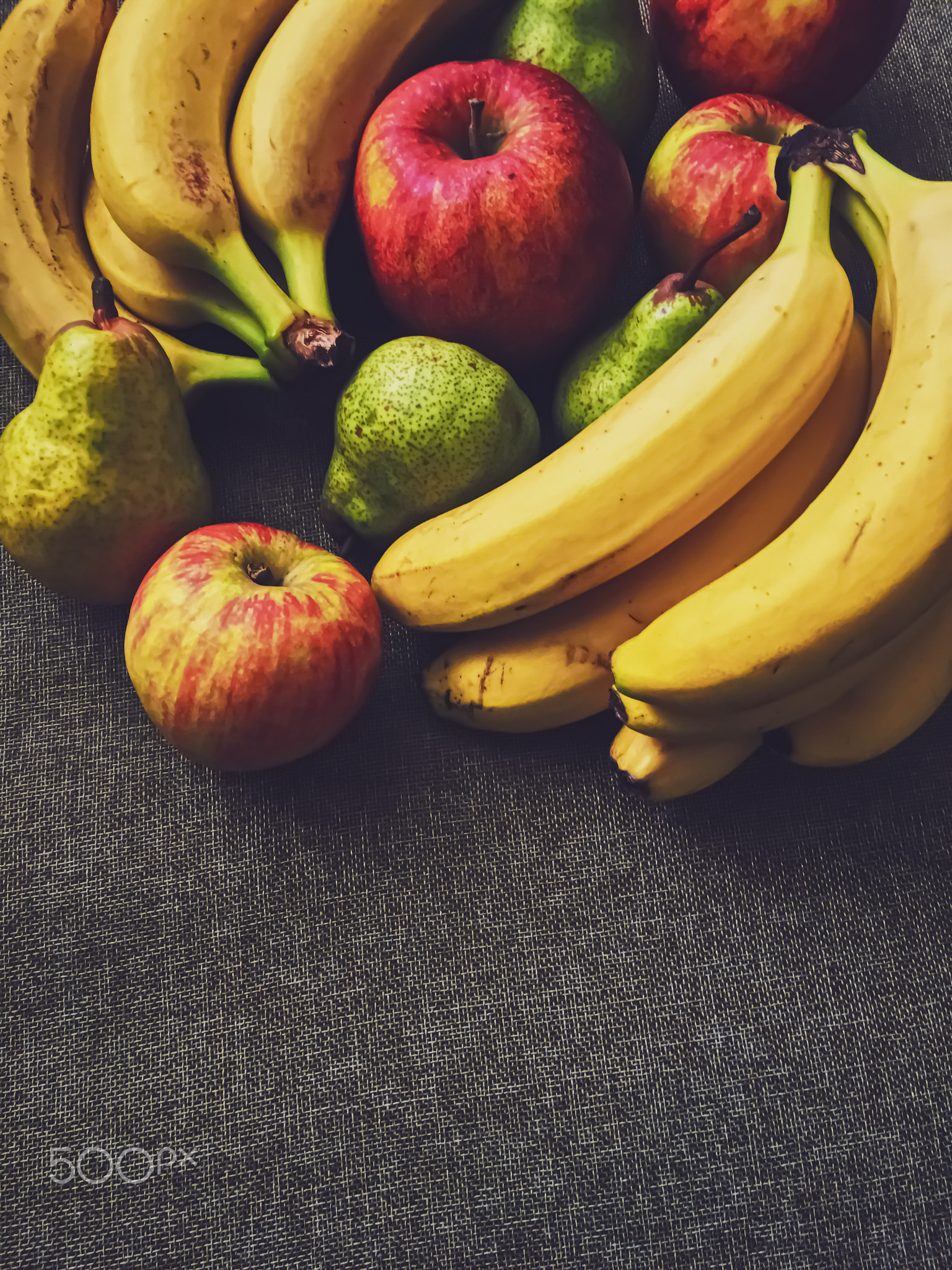 Organic apples, pears and bananas on rustic linen background