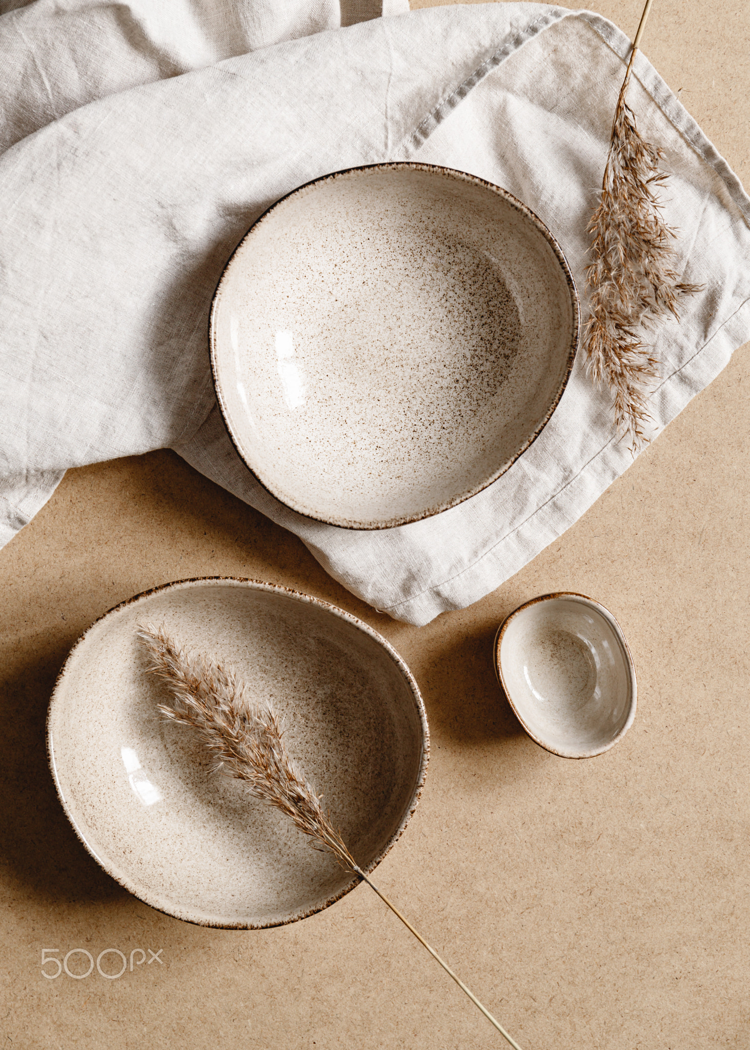 Modern minimalist ceramics set with a linen cloth over kraft paper