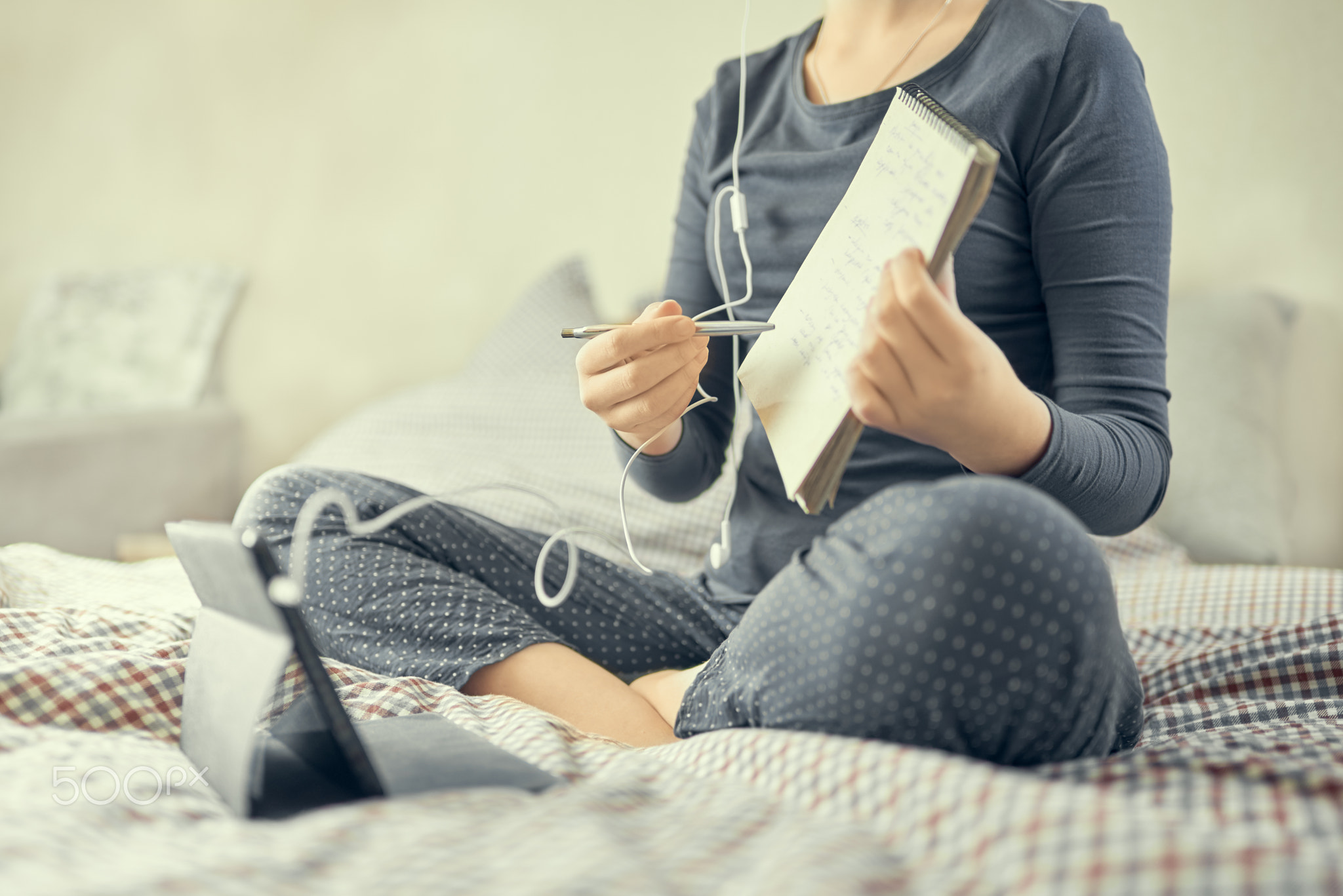 Studious student studying online at home. The girl shows notes in a