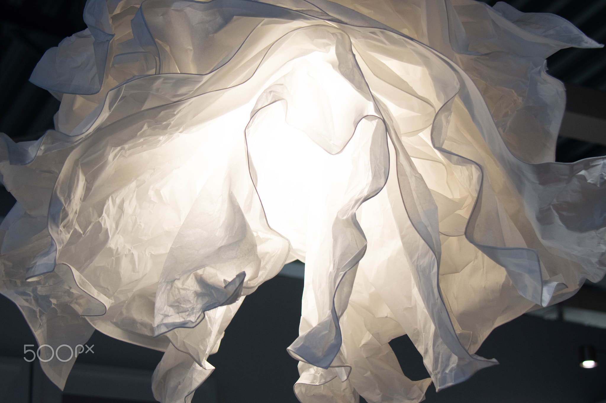 Crumpled paper white lamp on the ceiling. The design of the apartment.