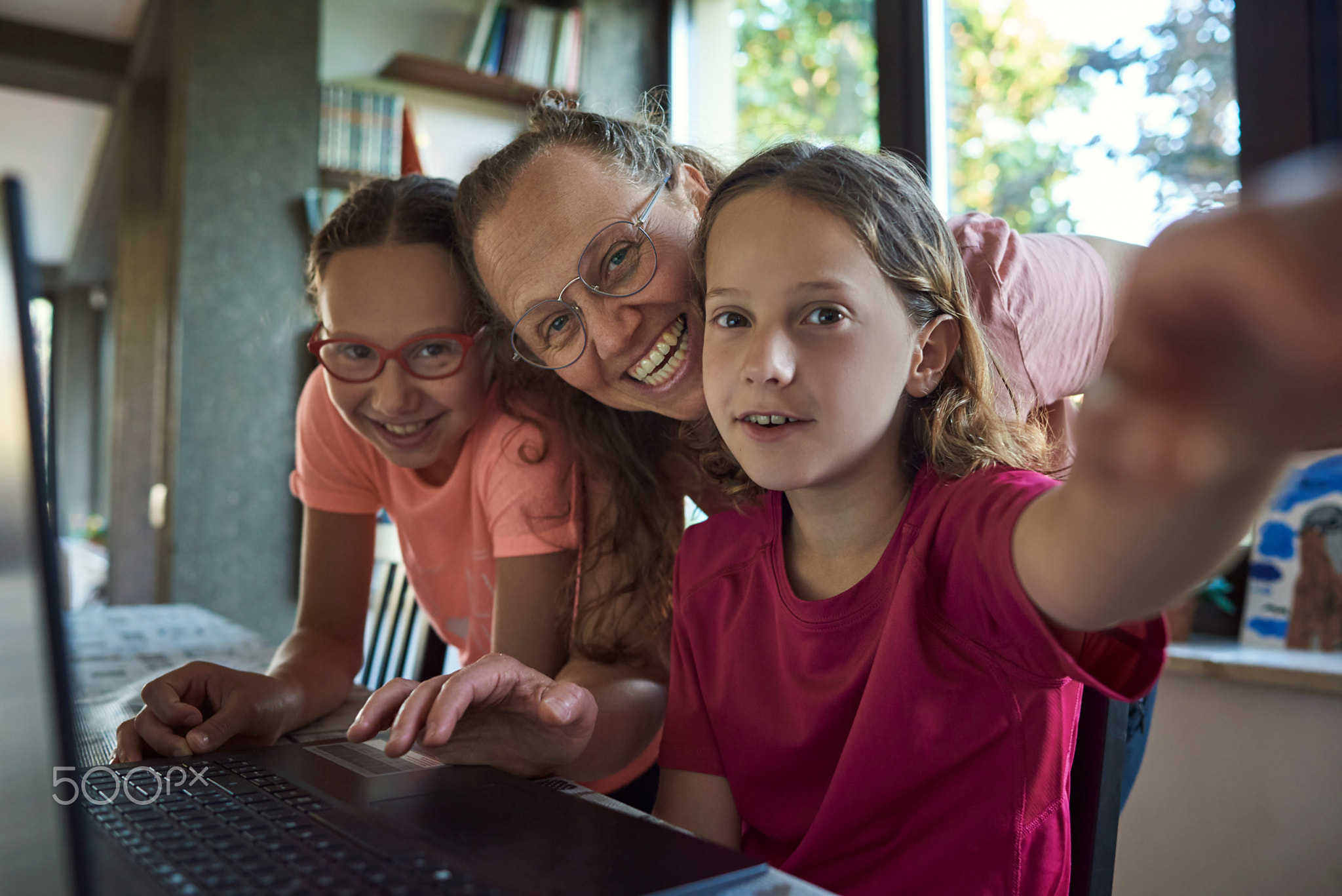 Mother helping for two girls infront of the laptop