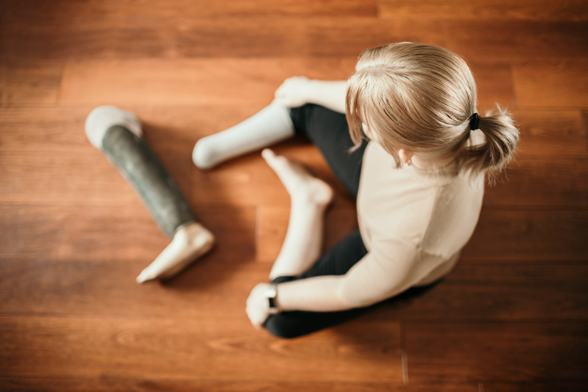 Blonde Amputee Sitting on Floor with Prosthesis