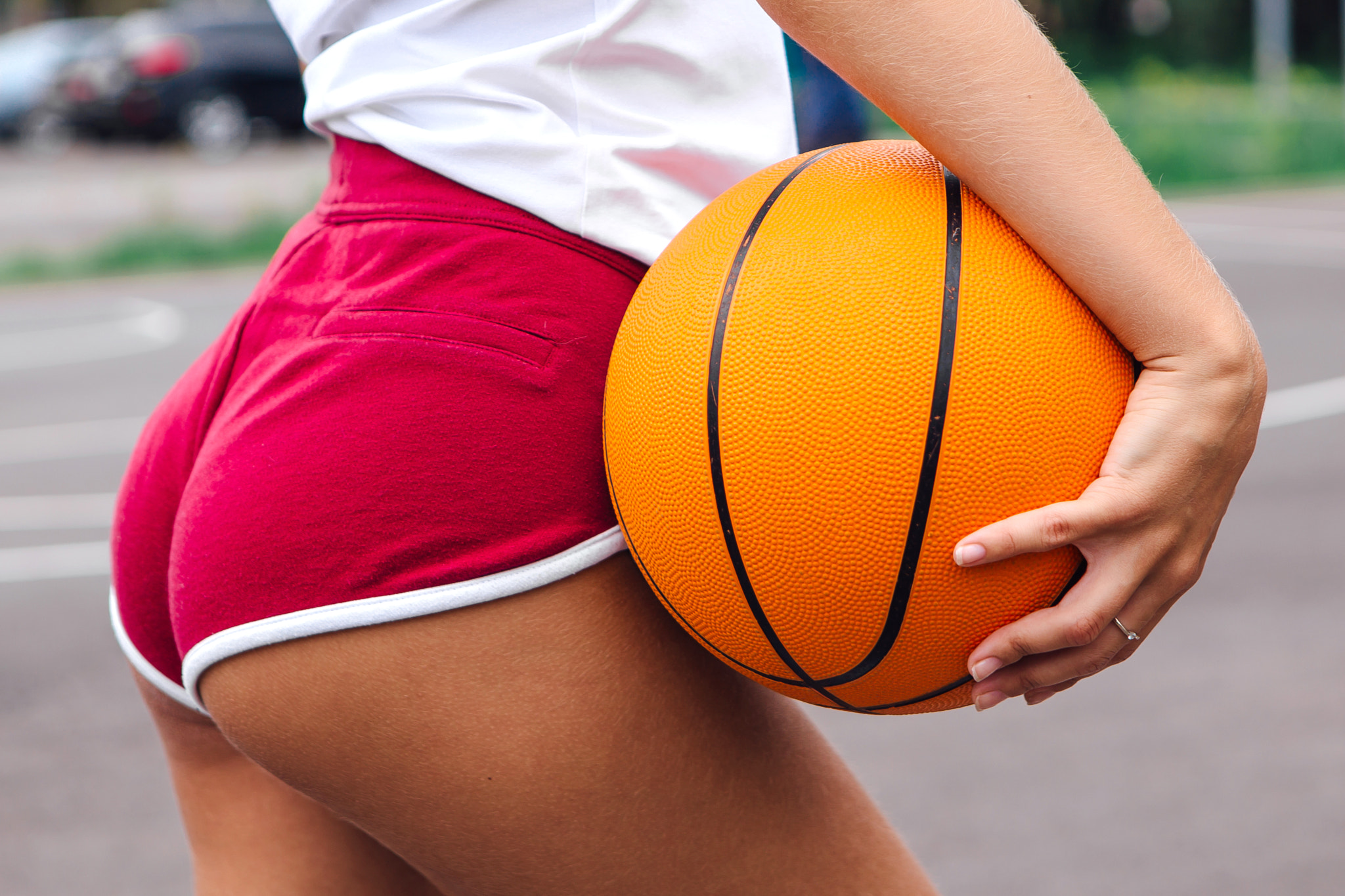 Young woman holding a ball on a basketball court.