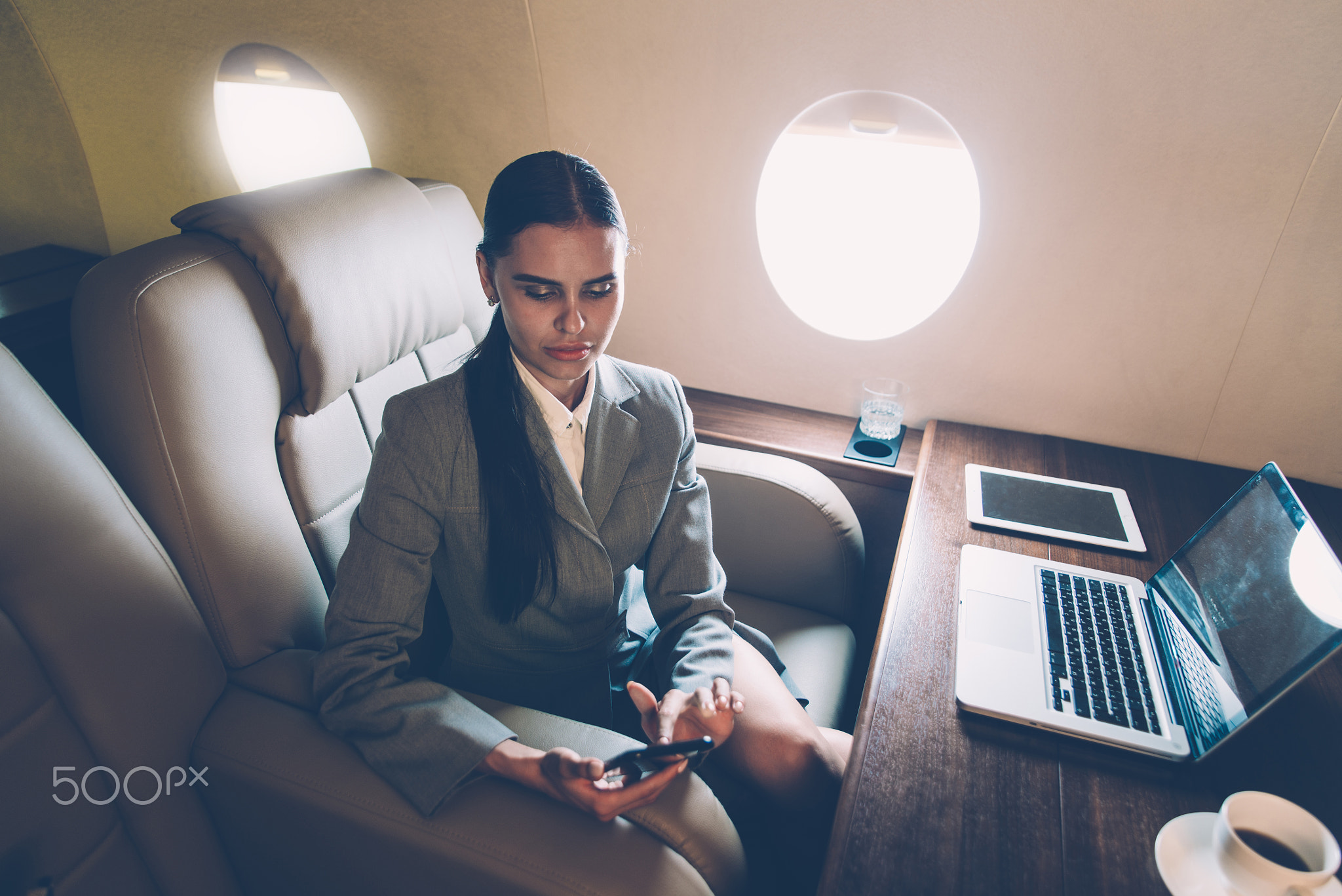 Business woman traveling and working on the private jet